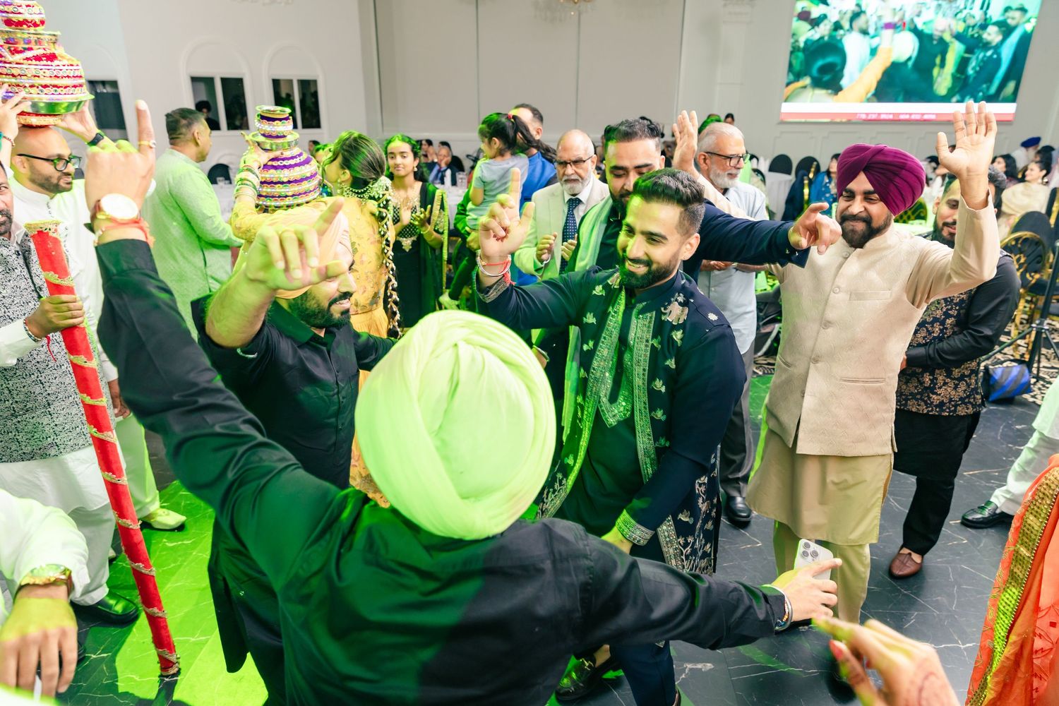 Lively celebration with guests dancing and enjoying festivities in a decorated indoor space.