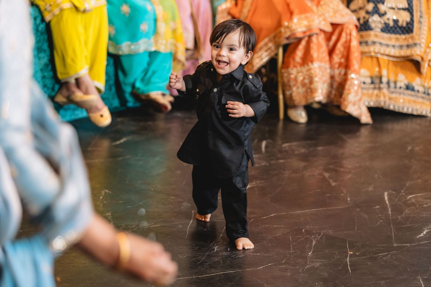 Guests dancing and celebrating at a vibrant cultural wedding reception with colorful decor.