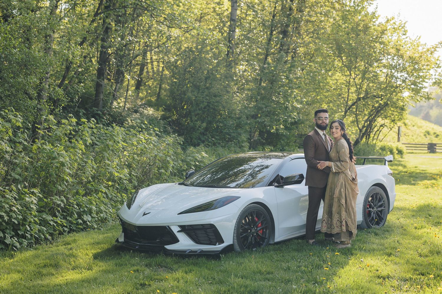 White luxury sports car parked in a lush green outdoor setting during a photo session.