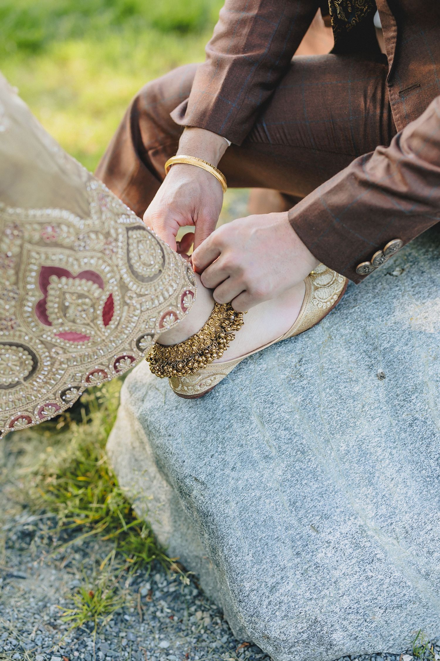Close-up of hands arranging decorative elements on a stone surface outdoors.