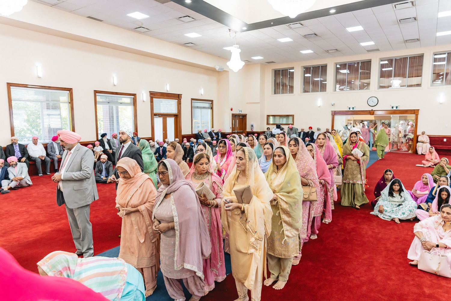 Wide view of a wedding ceremony hall filled with guests in traditional attire.