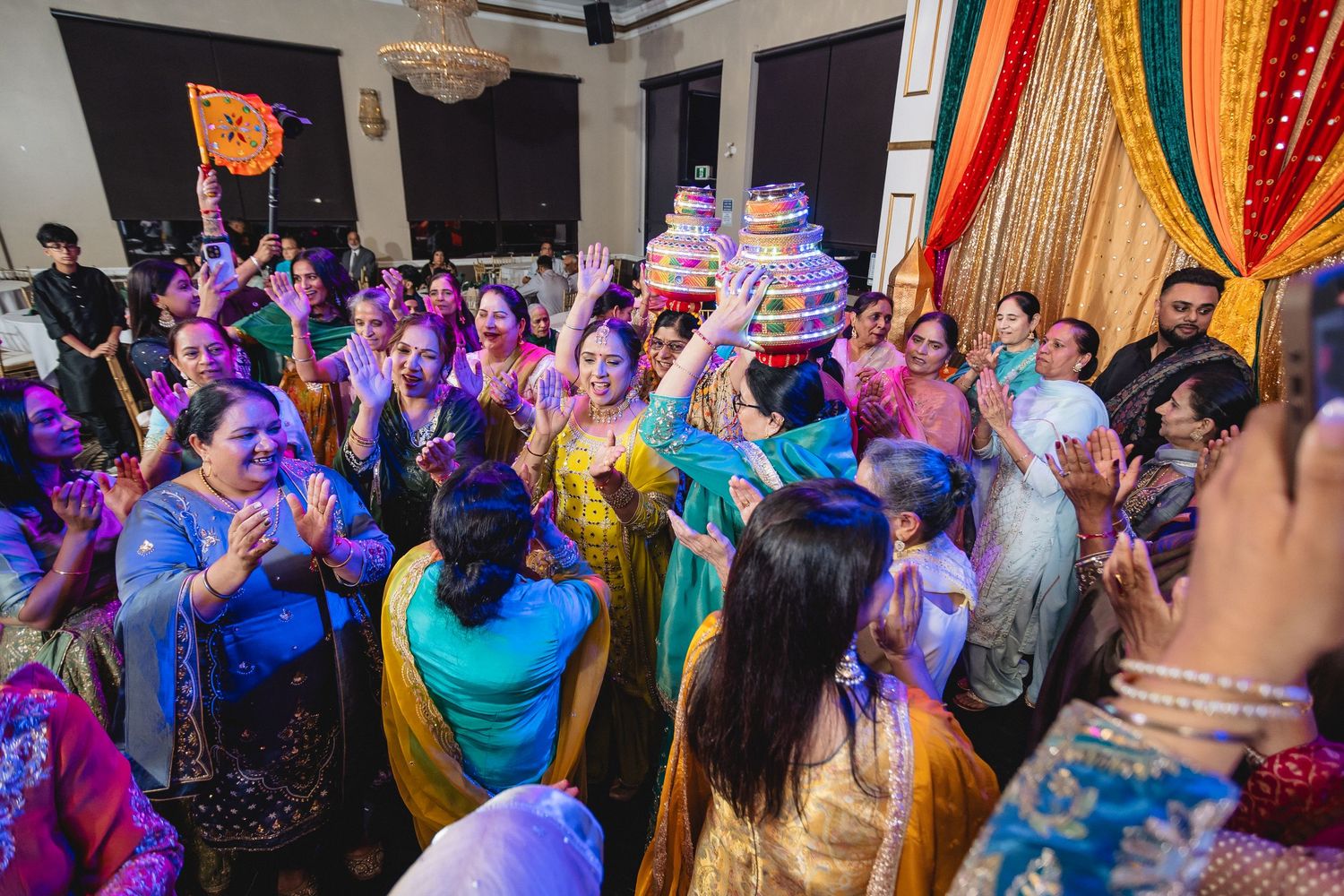 Celebration with colorful lights and decorations as guests dance and celebrate at an Indian cultural event.