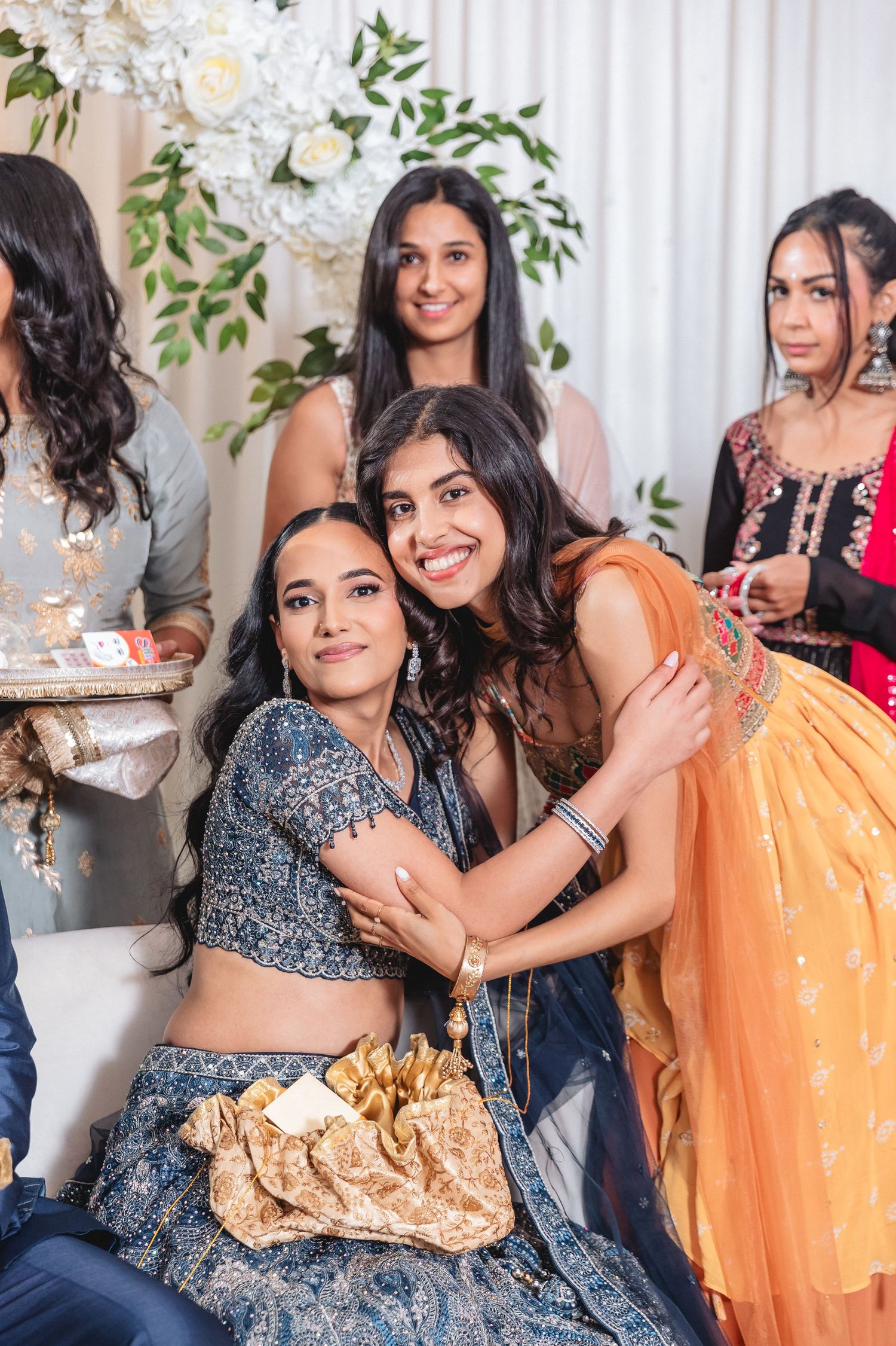 Celebration gathering with guests in sparkly lehengas and traditional Indian party wear.