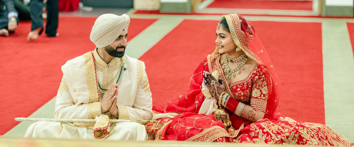 Traditional Indian wedding ceremony setup with vibrant red decor and floral arrangements.