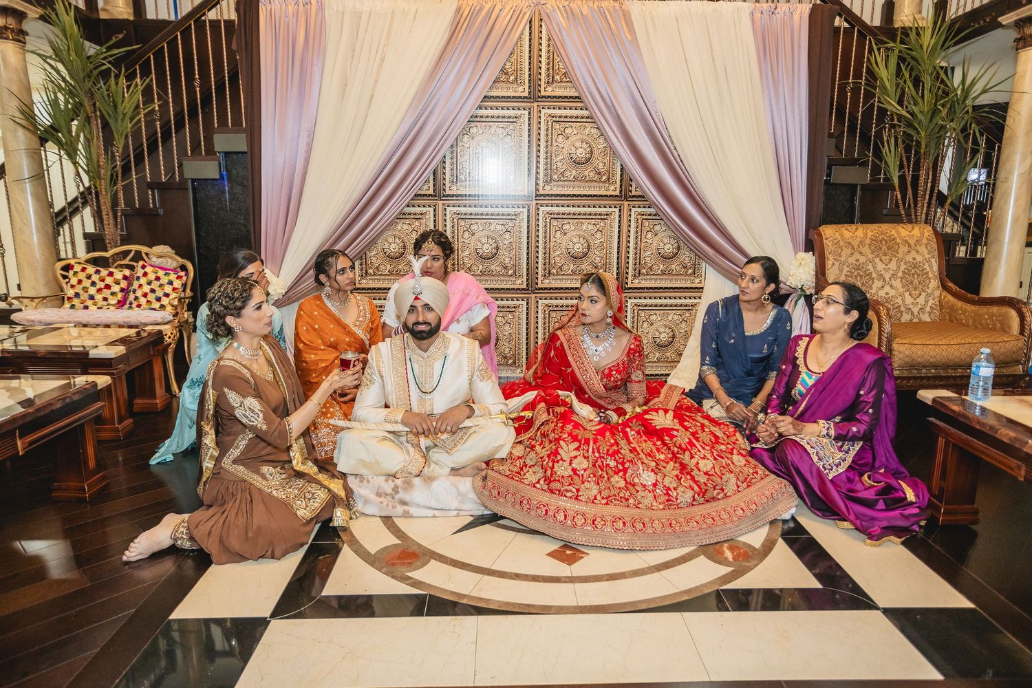Wedding ceremony setup with elegant drapes and traditional decor in indoor venue.