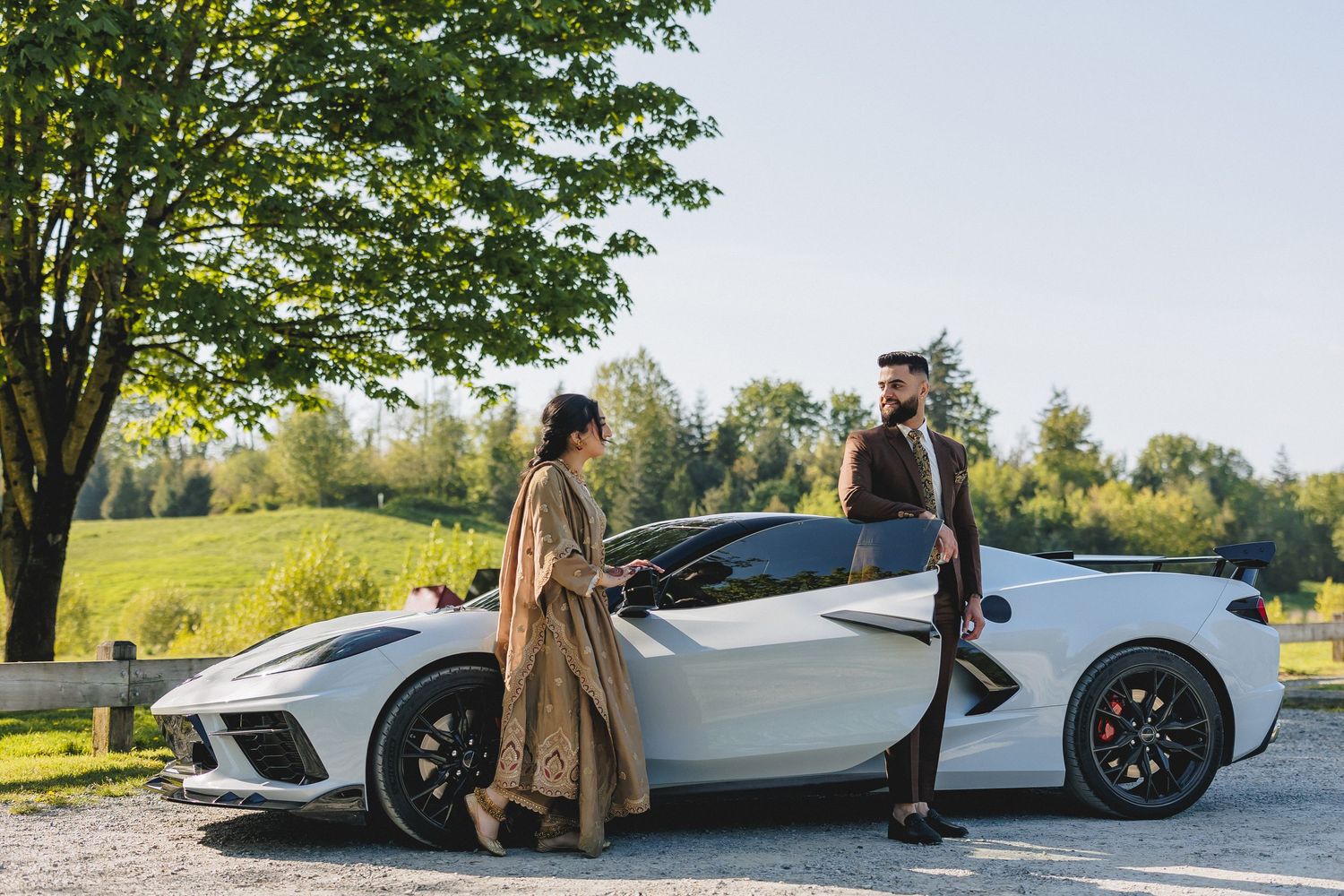 White luxury sports car parked on a scenic hilltop during a sunny day.