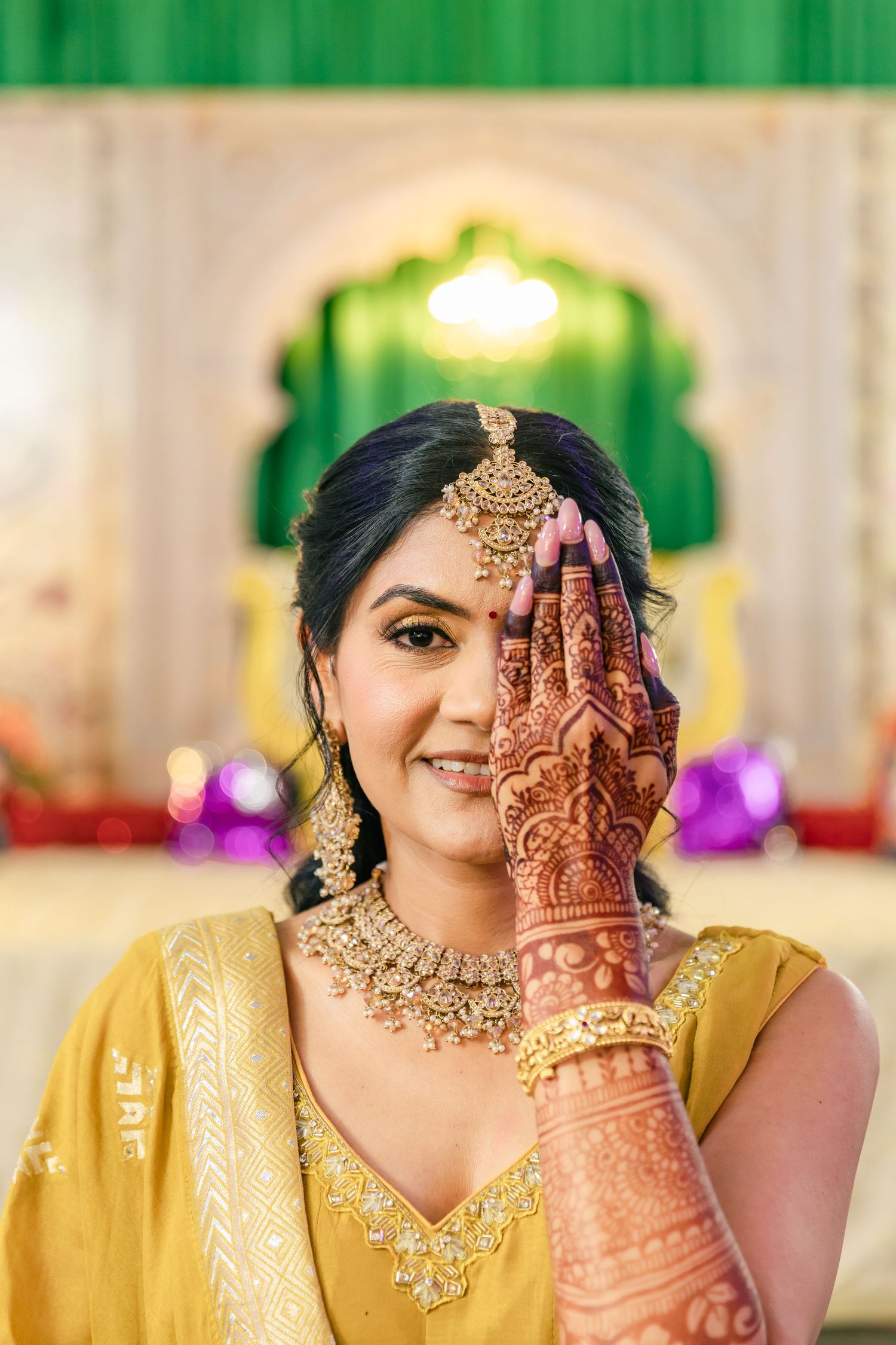 Close-up shots of intricate henna designs on hands with traditional Indian jewelry and yellow attire.