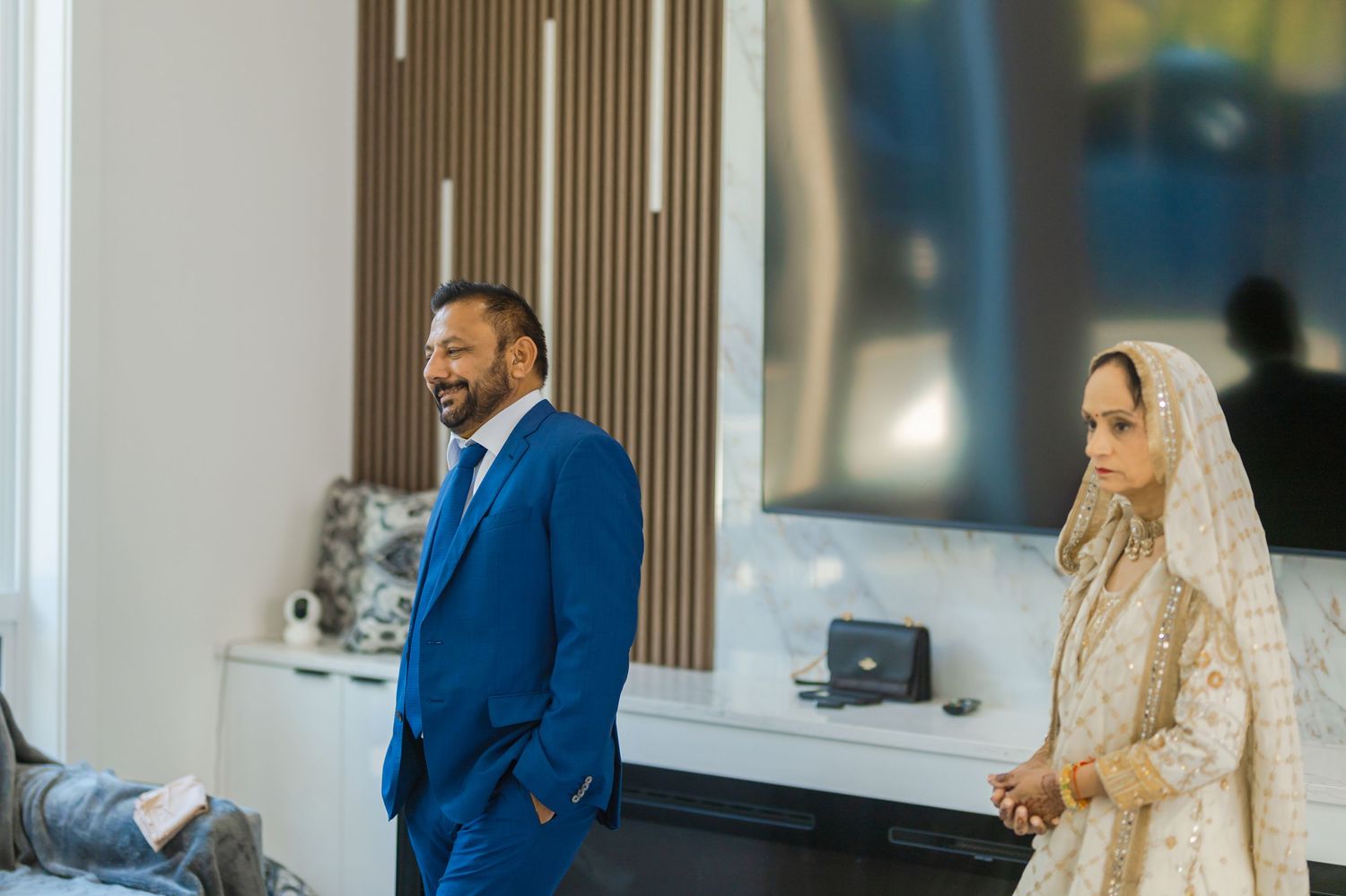 Wedding ceremony with guests in formal attire seated in a modern venue.