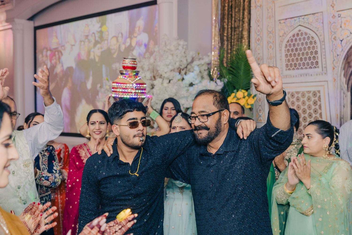 Wedding celebration with guests dancing and enjoying themselves in a decorated indoor venue.