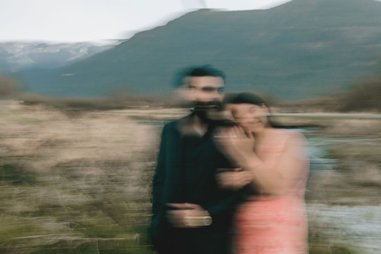 Artistic blurred motion shots of couple in natural outdoor setting with mountains.