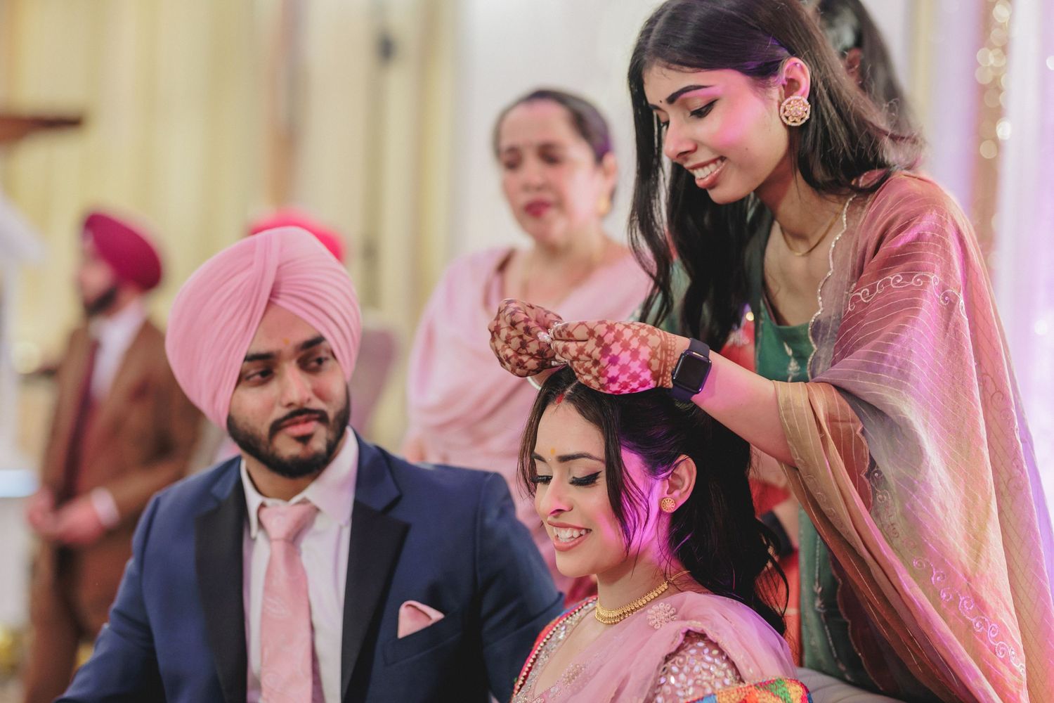 Wedding guests help style the bride's hair during a traditional pre-wedding ceremony.