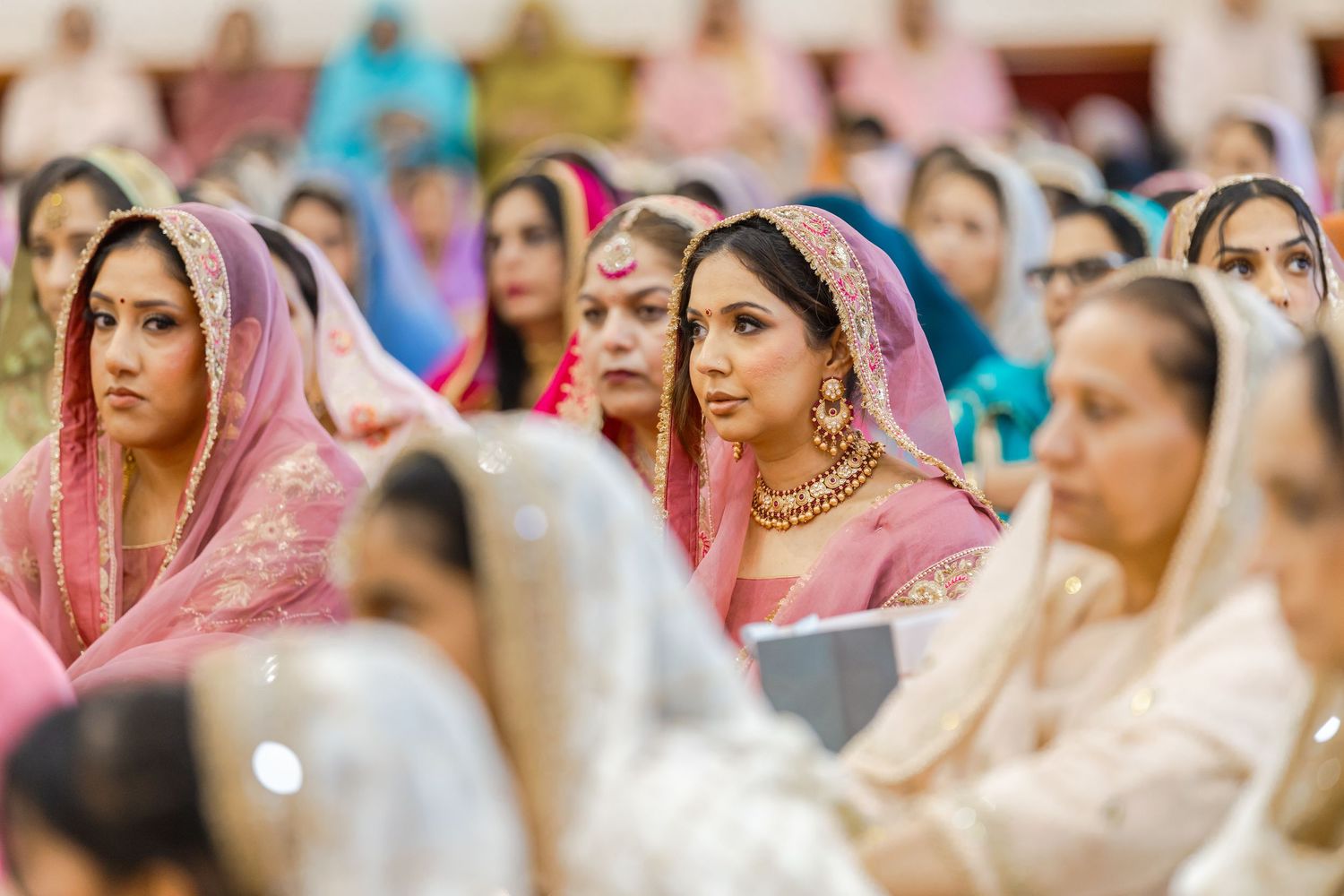 Traditional Sikh wedding ceremony with guests wearing colorful traditional attire.