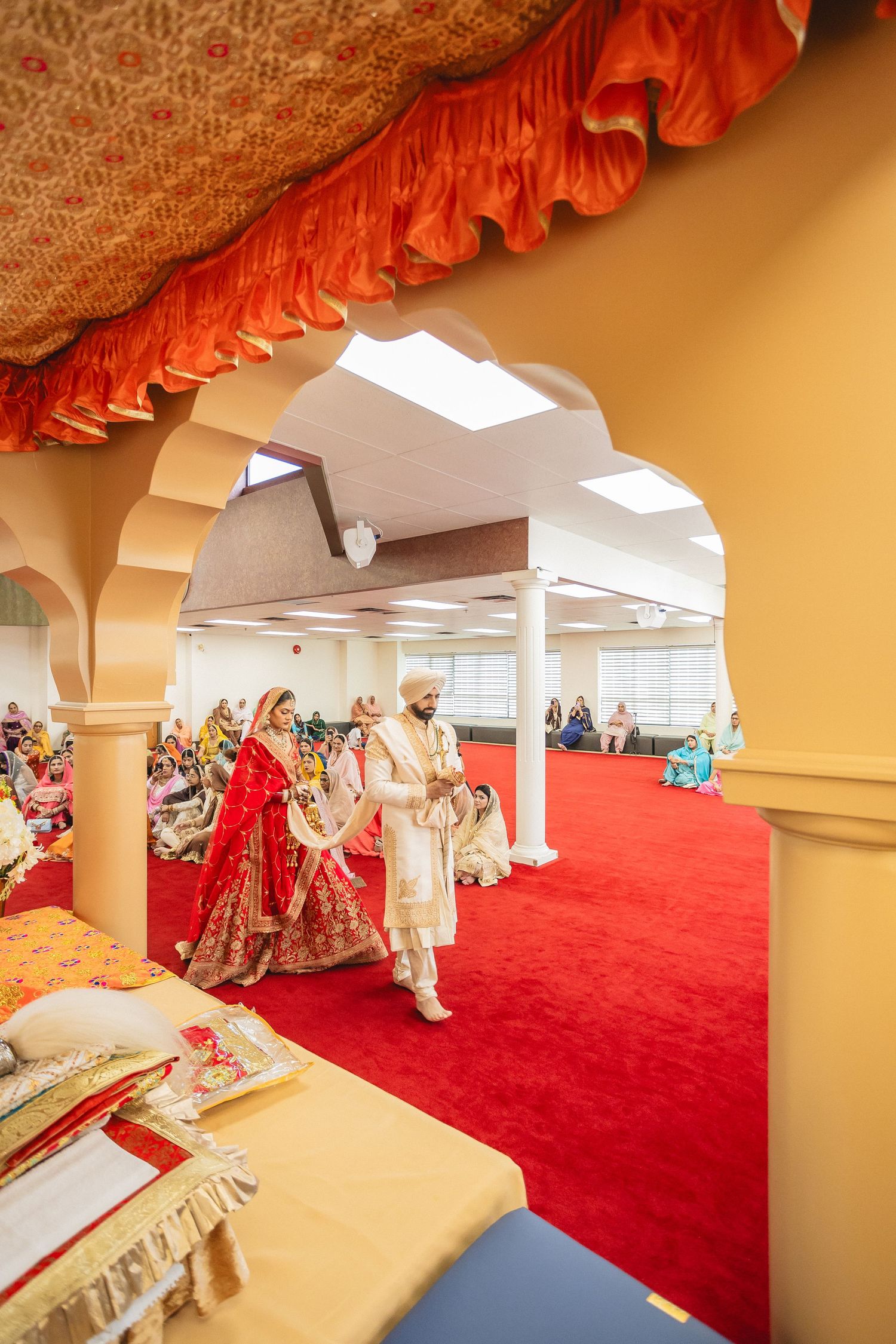 Interior view of wedding venue with arched doorways and red carpet leading through.