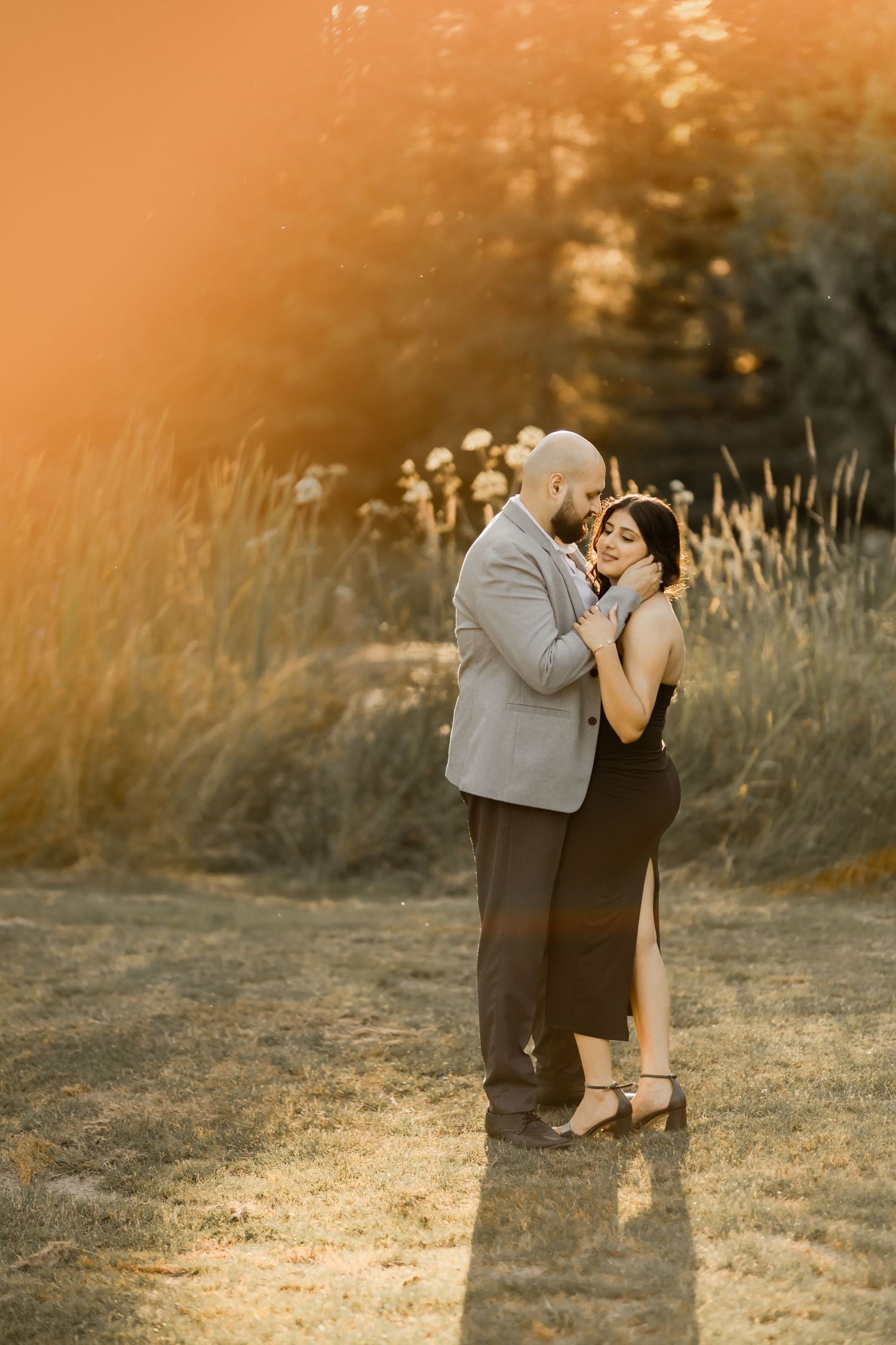 A romantic sunset photoshoot in a golden field during magic hour.