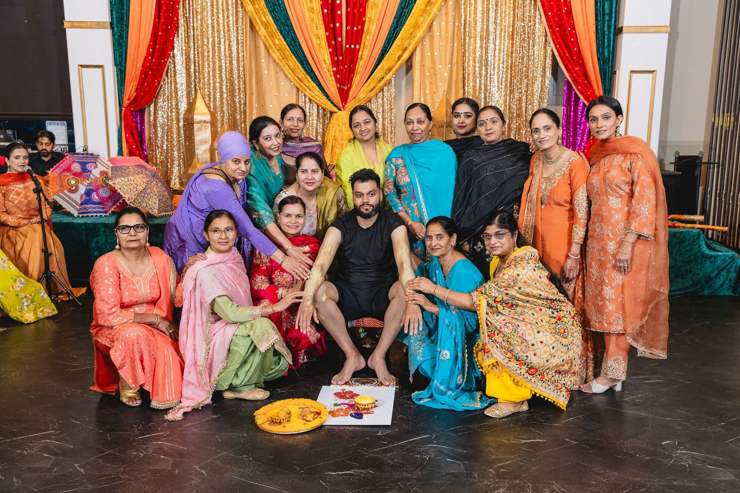 Panoramic view of guests in vibrant Indian formal wear seated together at a festive gathering.