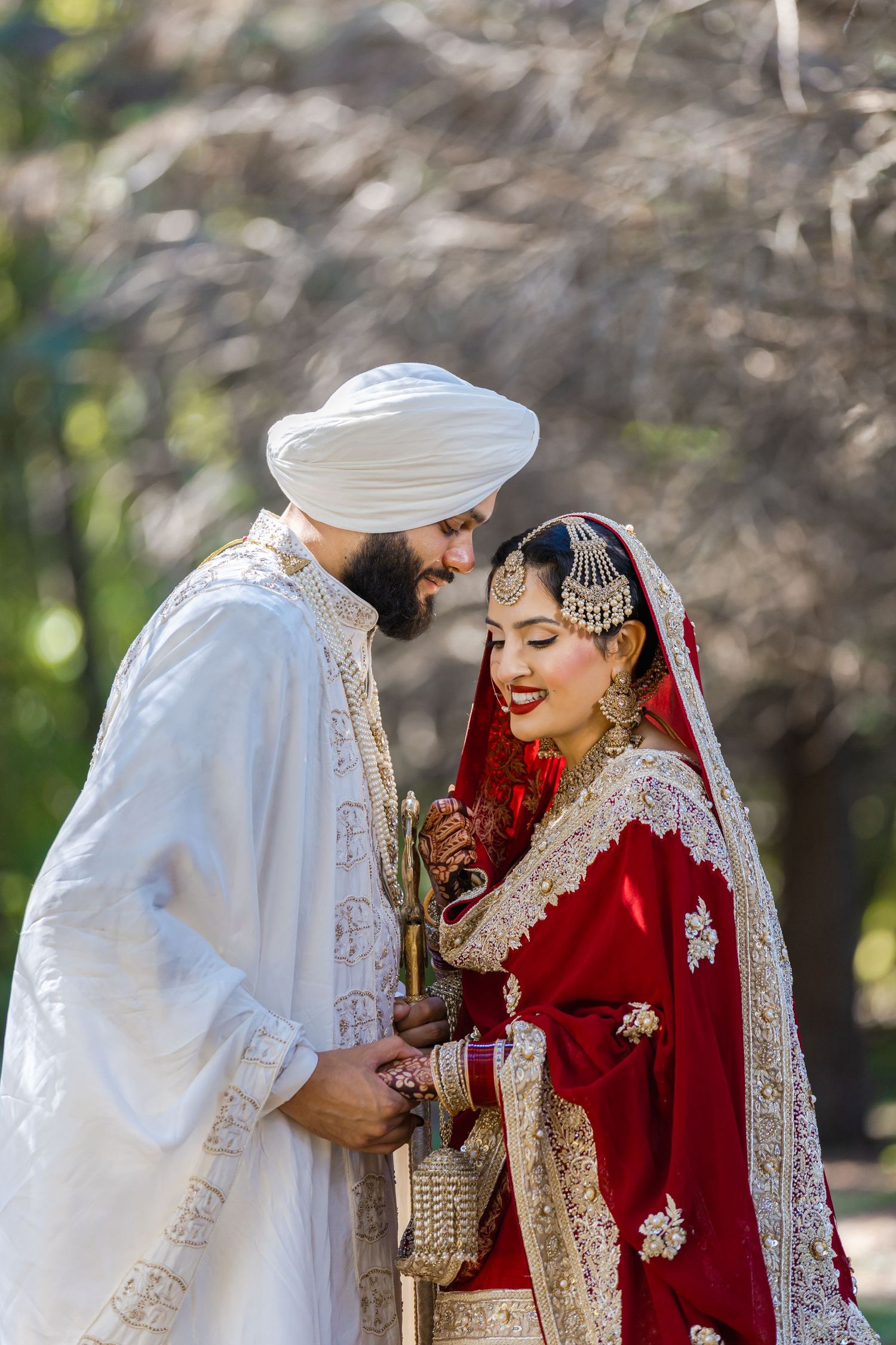 Traditional wedding ceremony with couple in red and white attire outdoors.