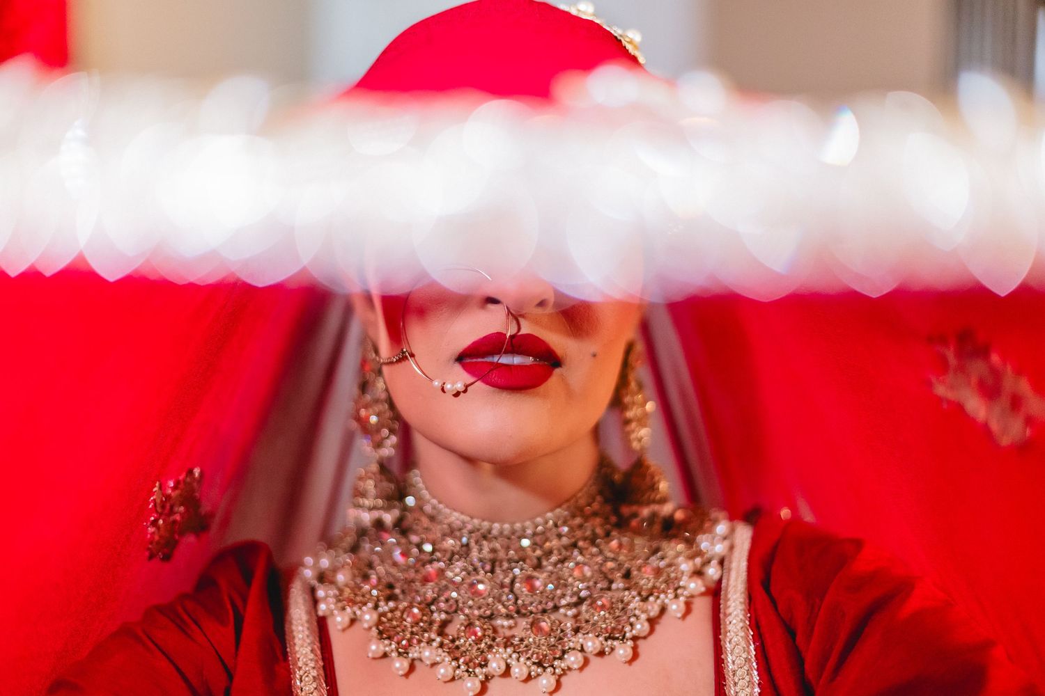 Luxurious wedding jewelry and accessories with red and gold accents.