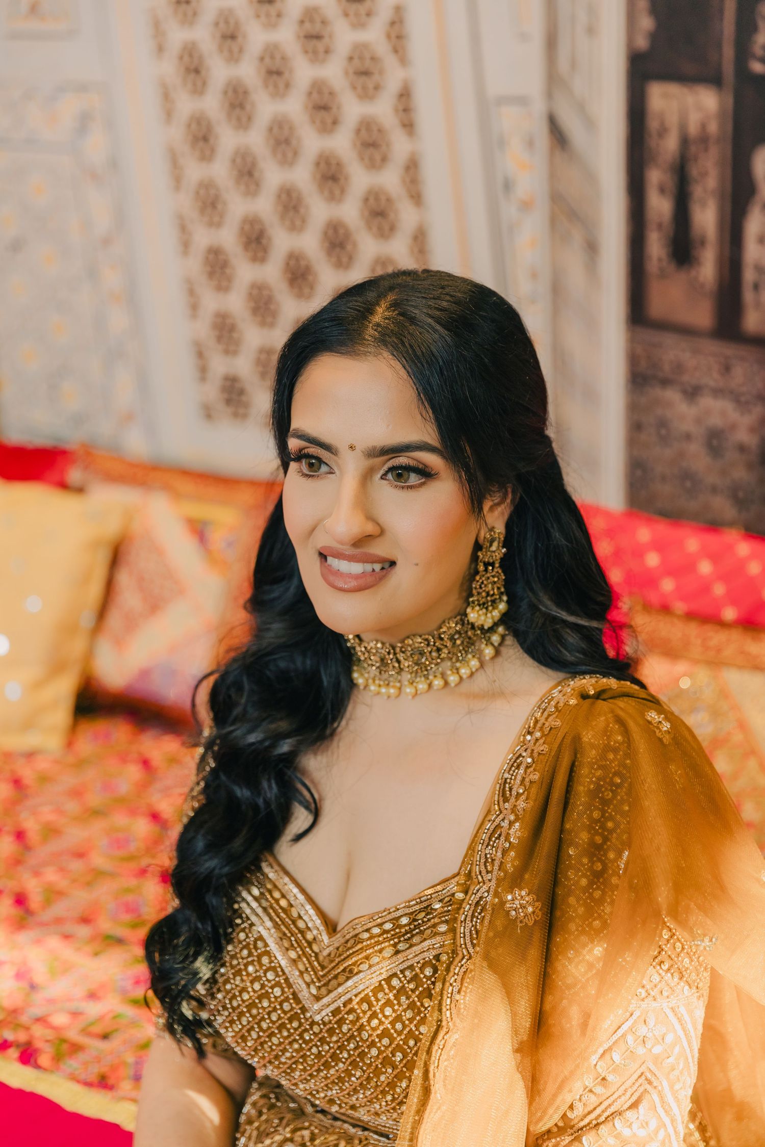 Ornate gold embroidered lehenga and jewelry details from an Indian wedding celebration.