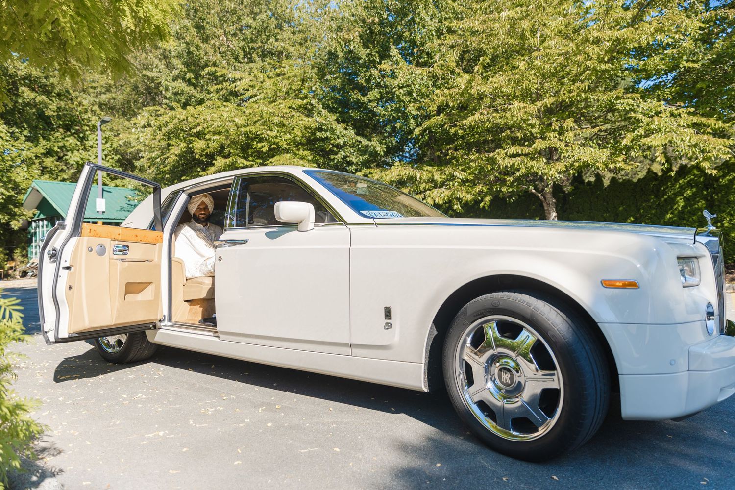 Luxury white Rolls Royce wedding car parked outdoors for special occasion.
