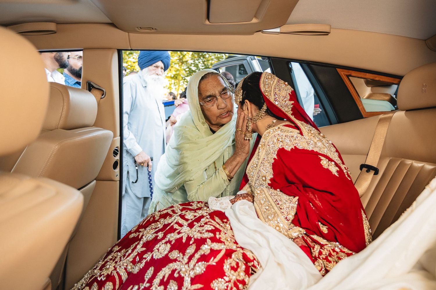 Interior view of a luxury car with beige leather seats and wedding decorations.