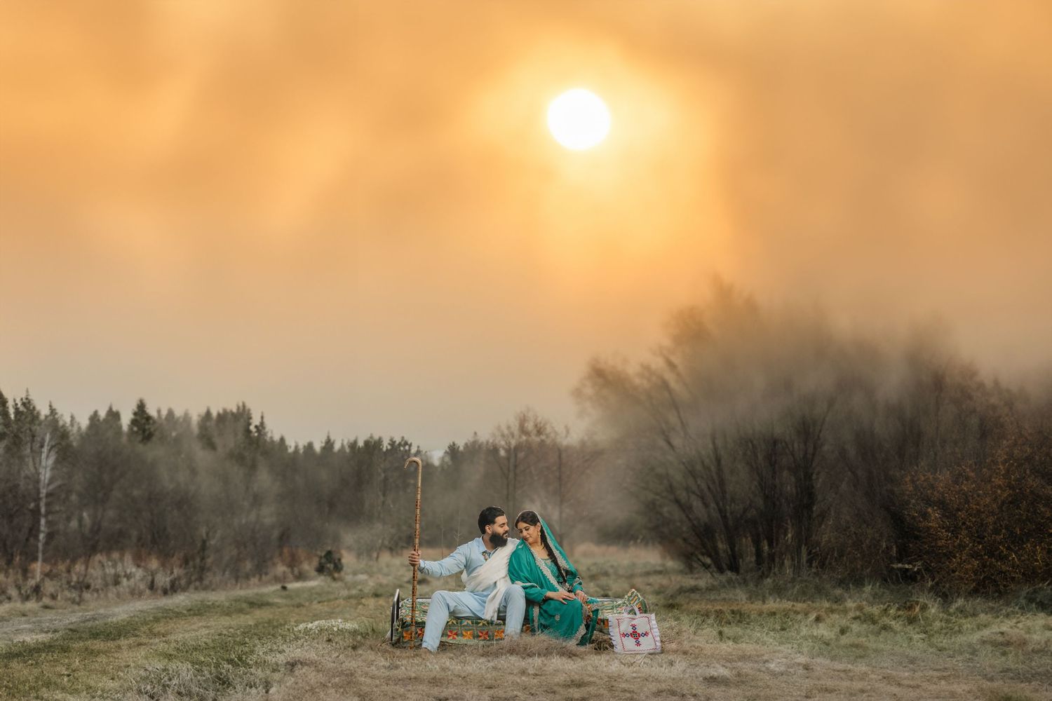 Golden sunset creates warm glow over mountain landscape during outdoor photo session. Punjabi Desi Couple Photoshoot in Canada