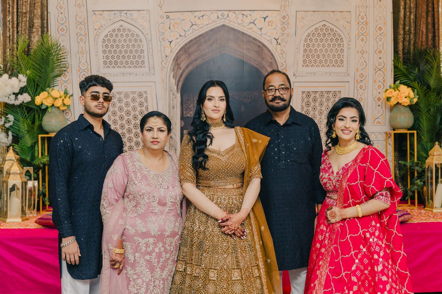 Group photo at an ornate venue with guests wearing traditional South Asian formal attire.