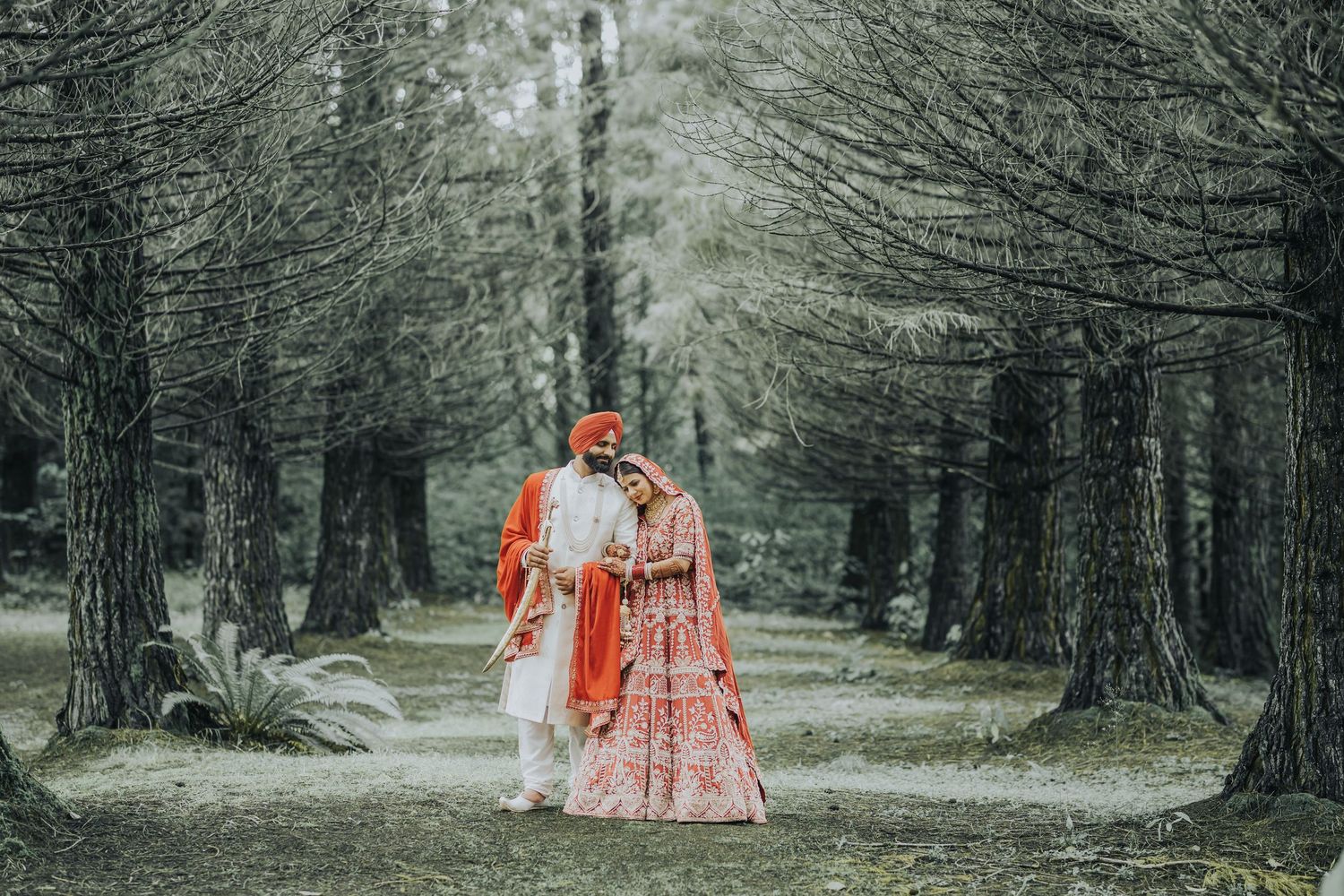 Romantic wedding photo series in a tree-lined path with dramatic lighting.