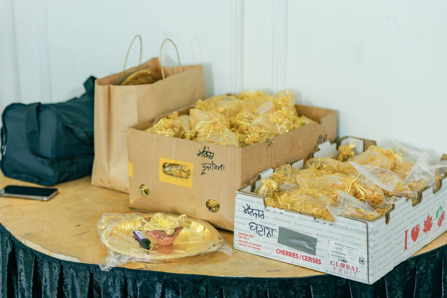 Multiple cardboard boxes filled with fresh yellow bread rolls displayed on a white counter surface.