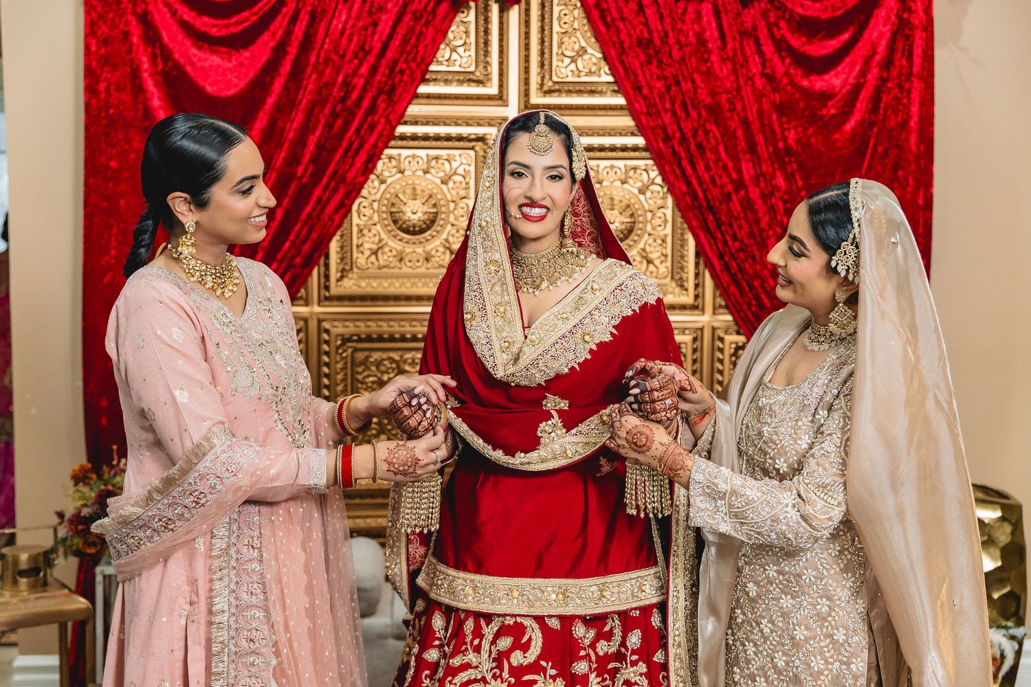 Traditional Sikh wedding ceremony with red and gold decor featuring ornate traditional attire and decorations.