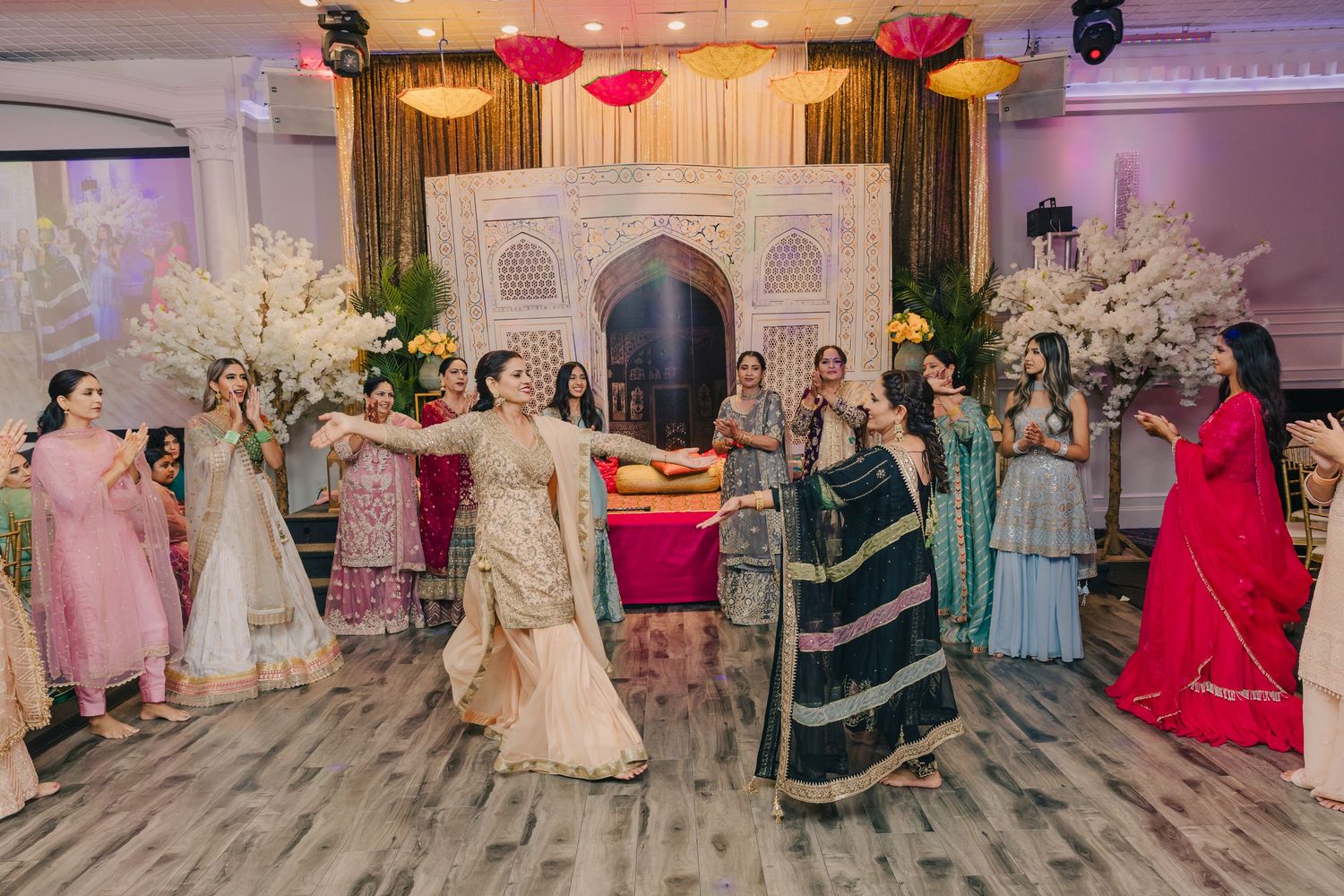 Wedding reception venue decorated with pink lighting and elegant table settings.