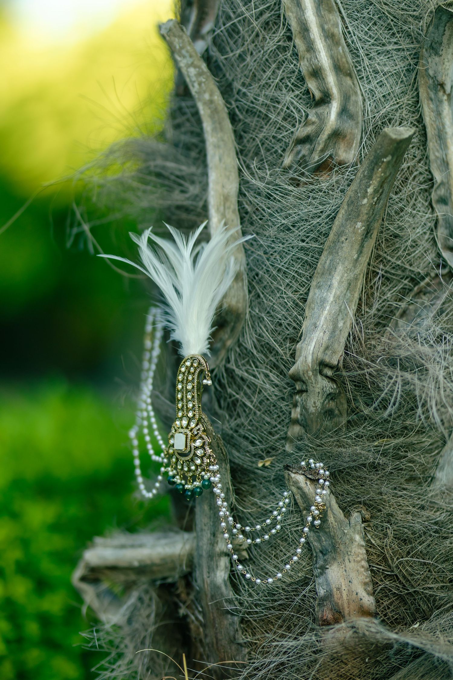 Decorative pearl and crystal accessories hanging on textured tree bark.