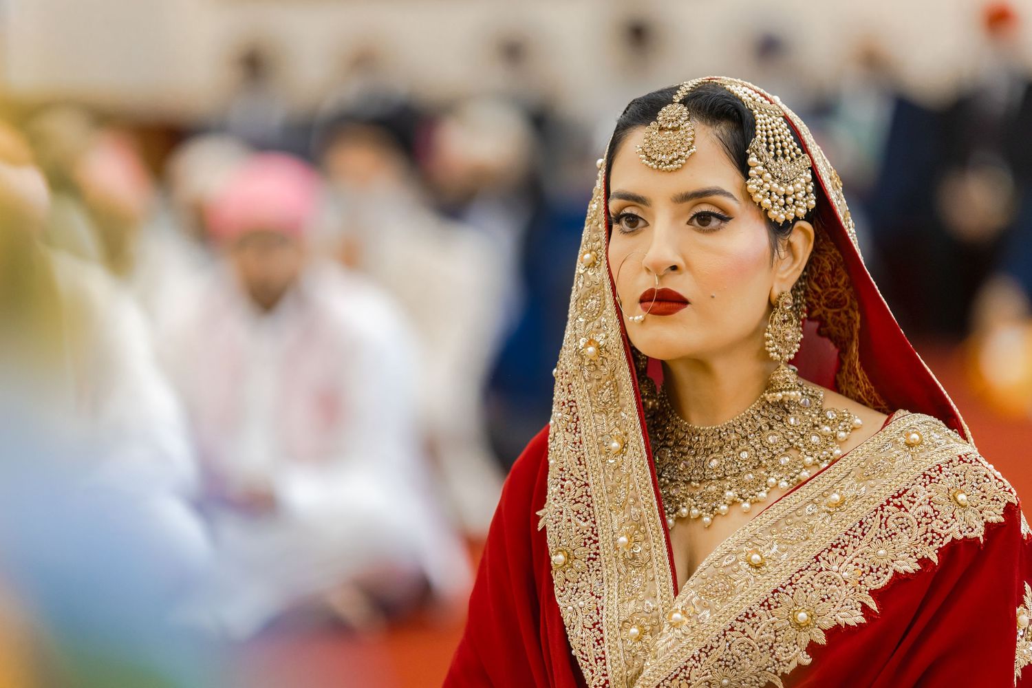 Traditional South Asian bride wearing ornate jewelry and red wedding attire.