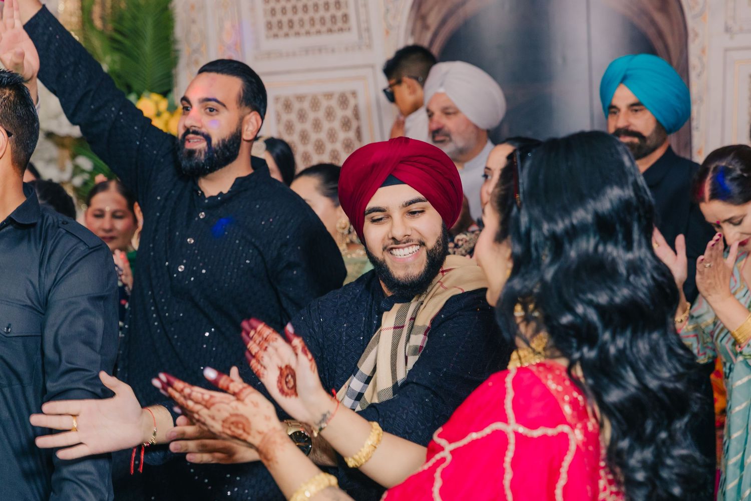 Festive wedding reception crowd dancing and celebrating in a beautifully decorated hall.