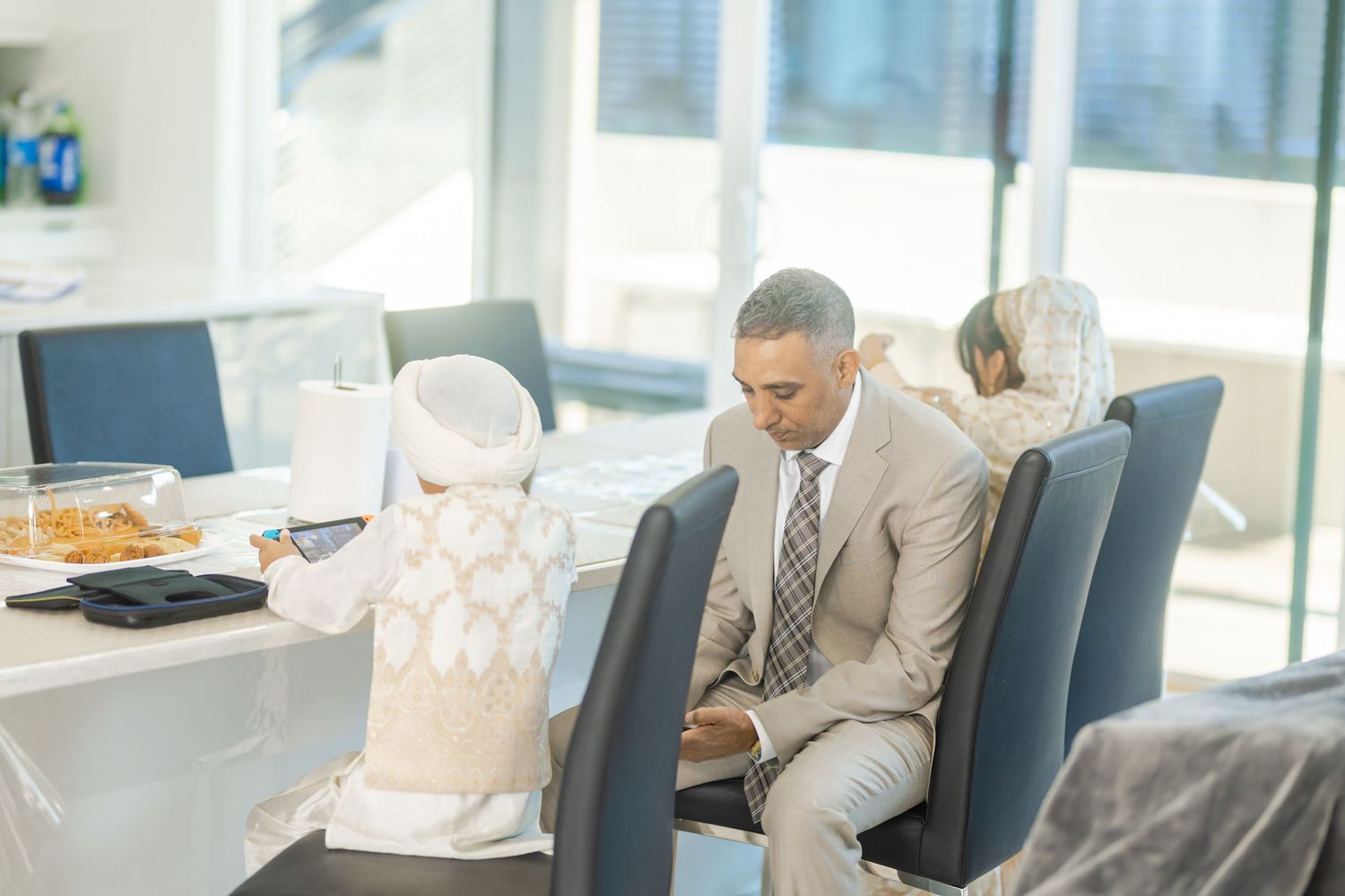 Professional meeting scene in modern office with people seated at conference table.