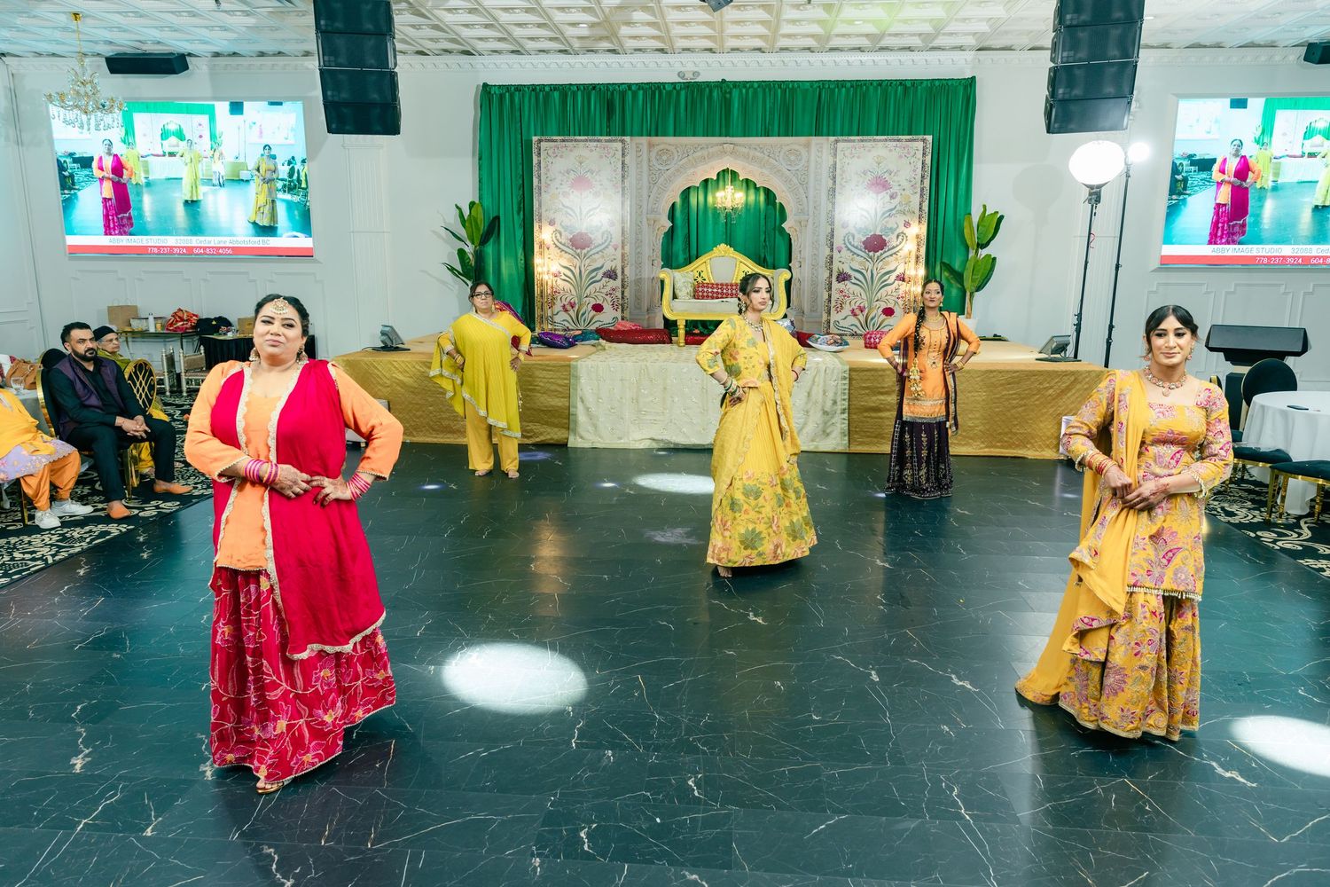 Dance performance in a spacious venue with colorful lighting and traditional decorations.