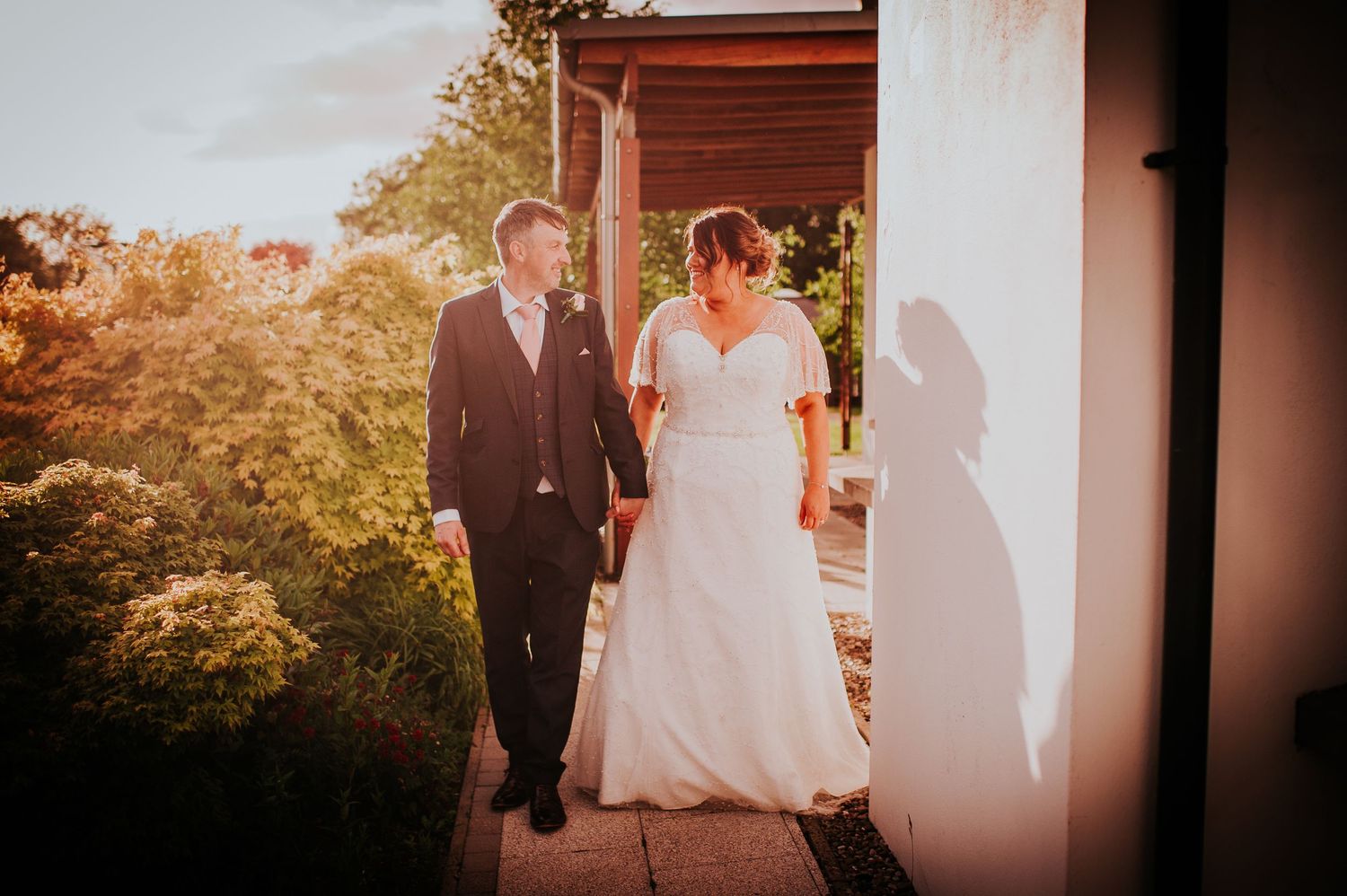 Silhouettes of wedding party members against sunset sky.