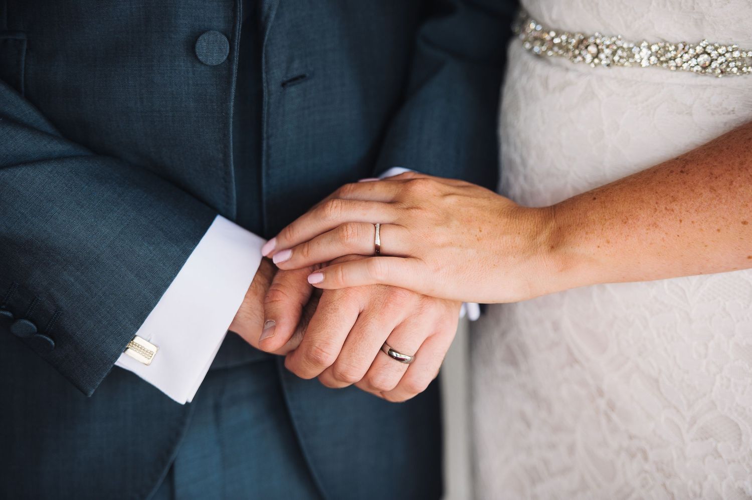A close-up series of hands exchanging small white paper cards or notes against a dark background.