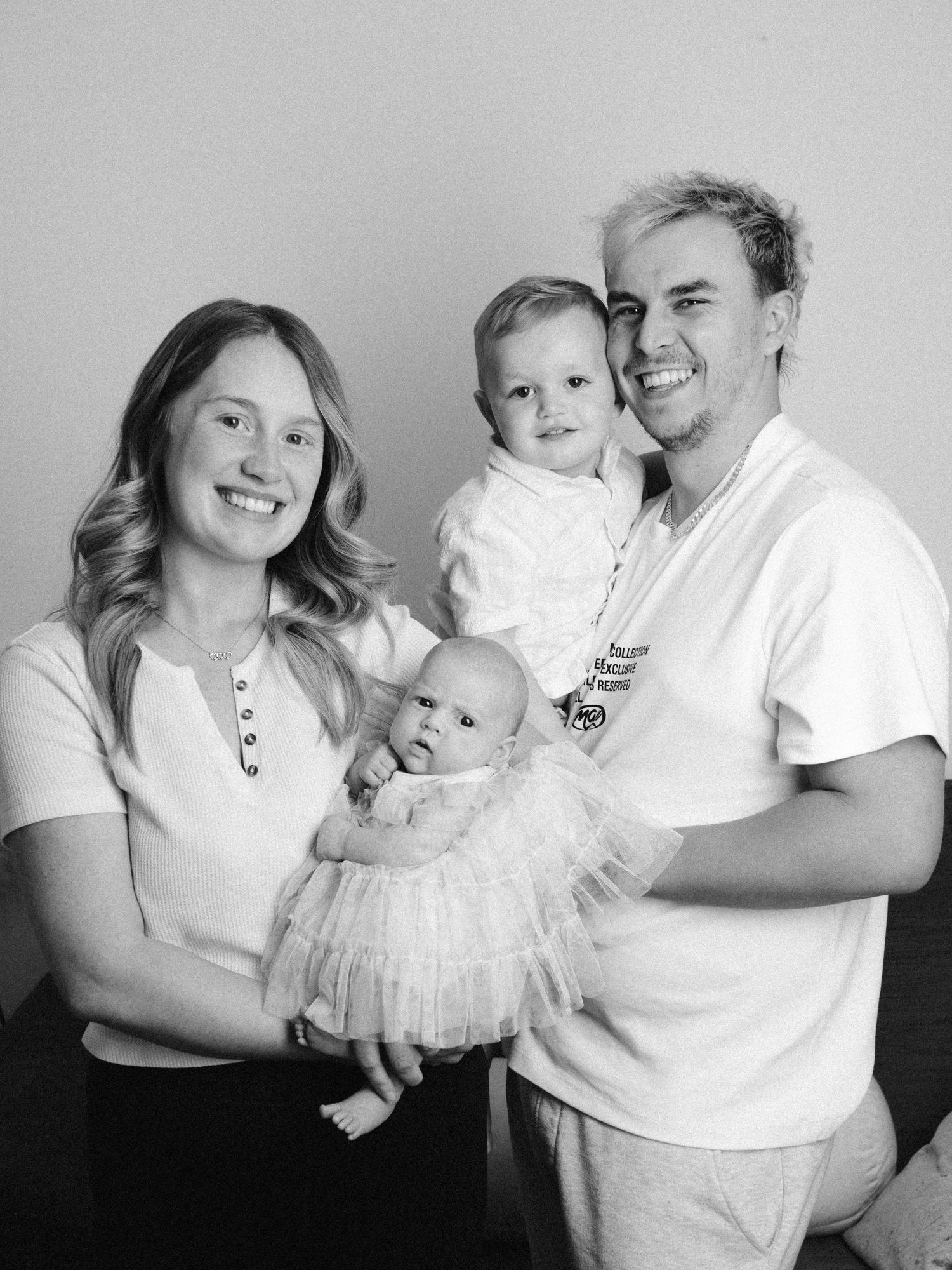 Black and white family portrait series showing joyful intimate moments.
