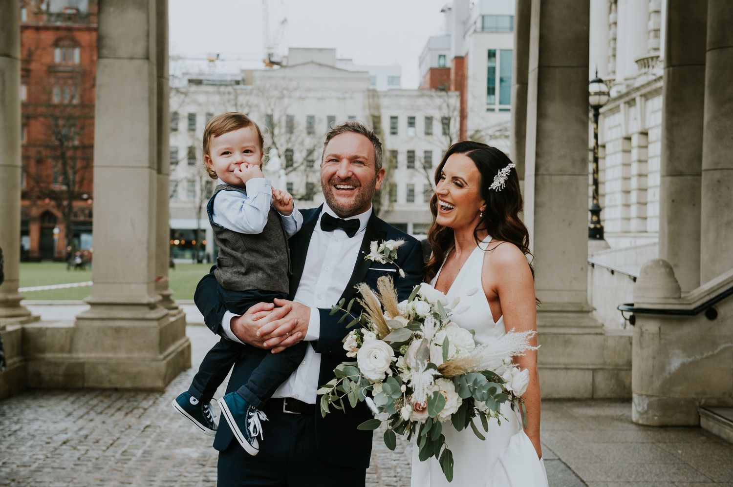 Candid wedding moments captured outside stately building with white columns.