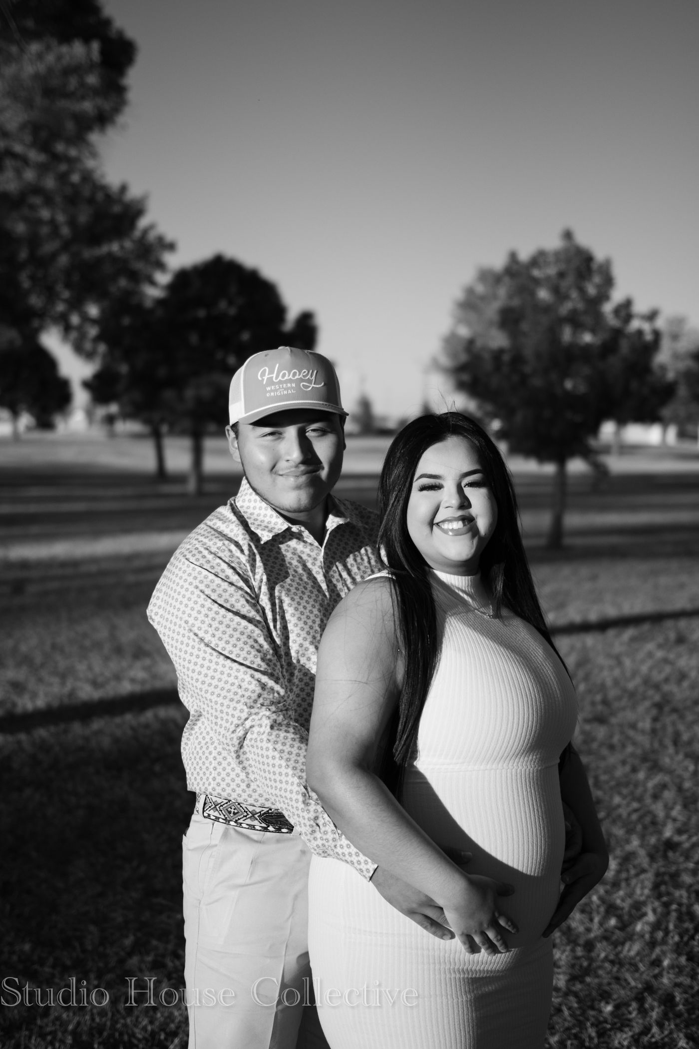 Black and white portrait of people embracing in an outdoor setting.