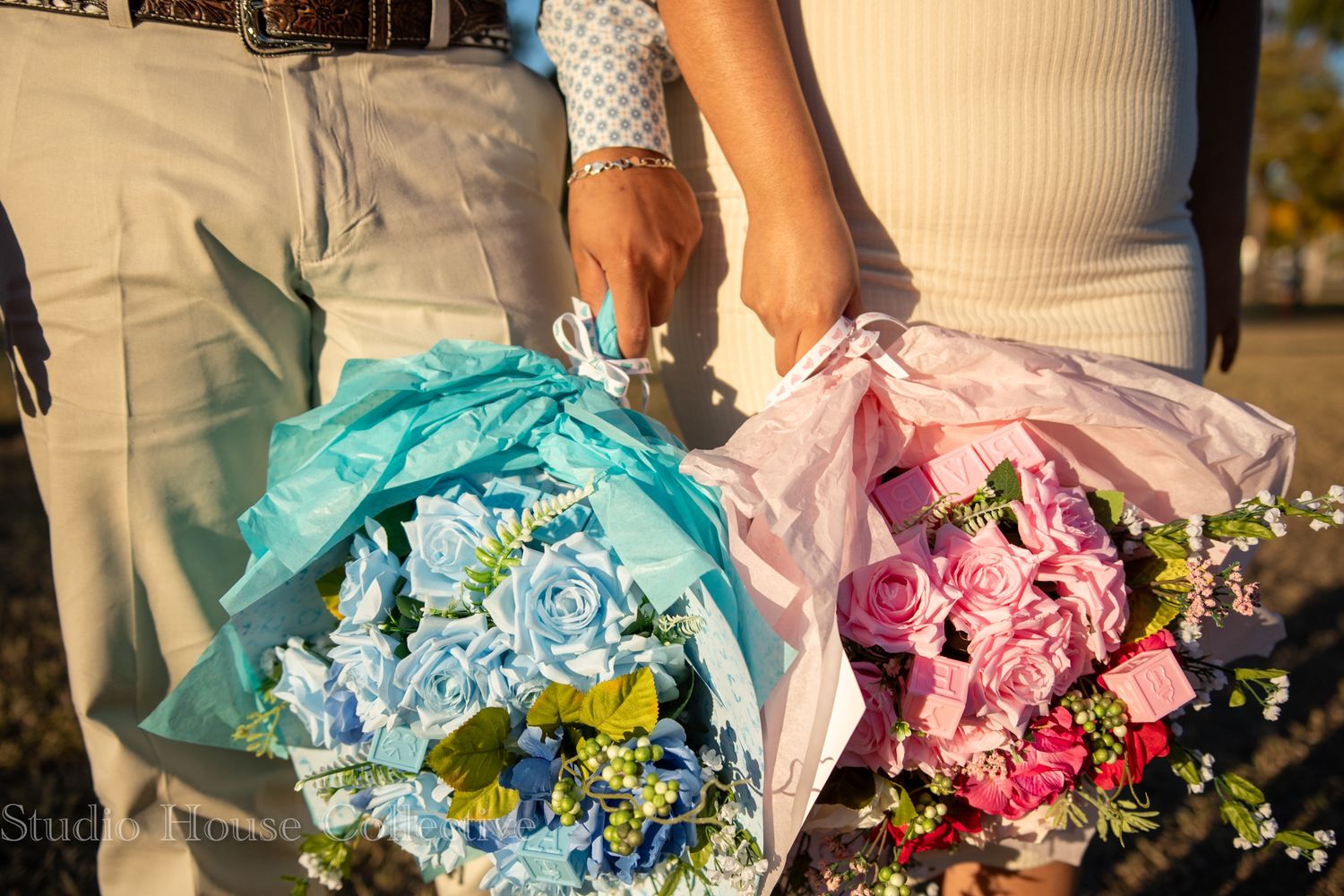 Bridesmaids holding vibrant blue and pink floral bouquets against a sunny outdoor backdrop.