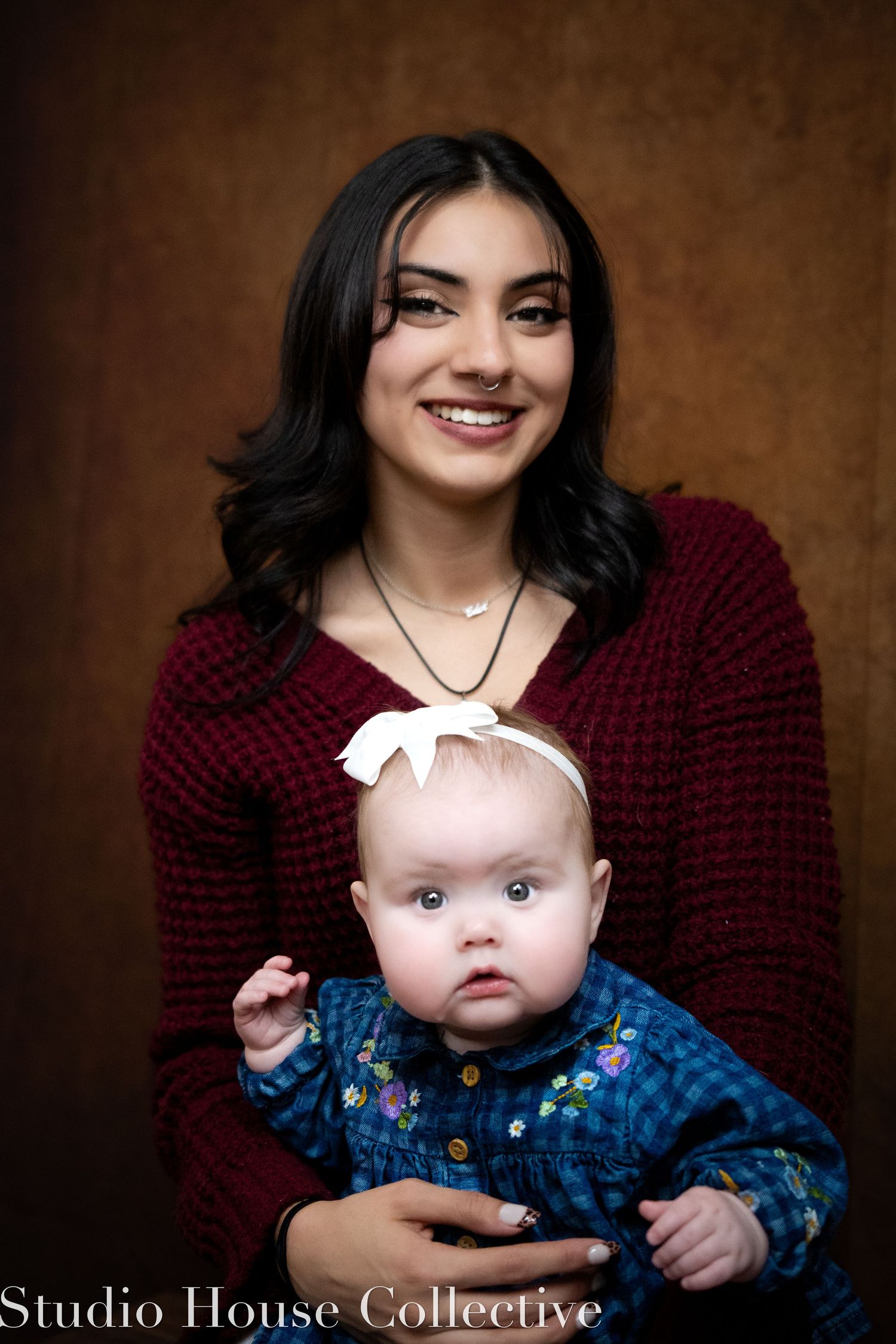 A series of studio portraits showing tender moments between a baby in blue floral clothing and someone in a burgundy sweater.