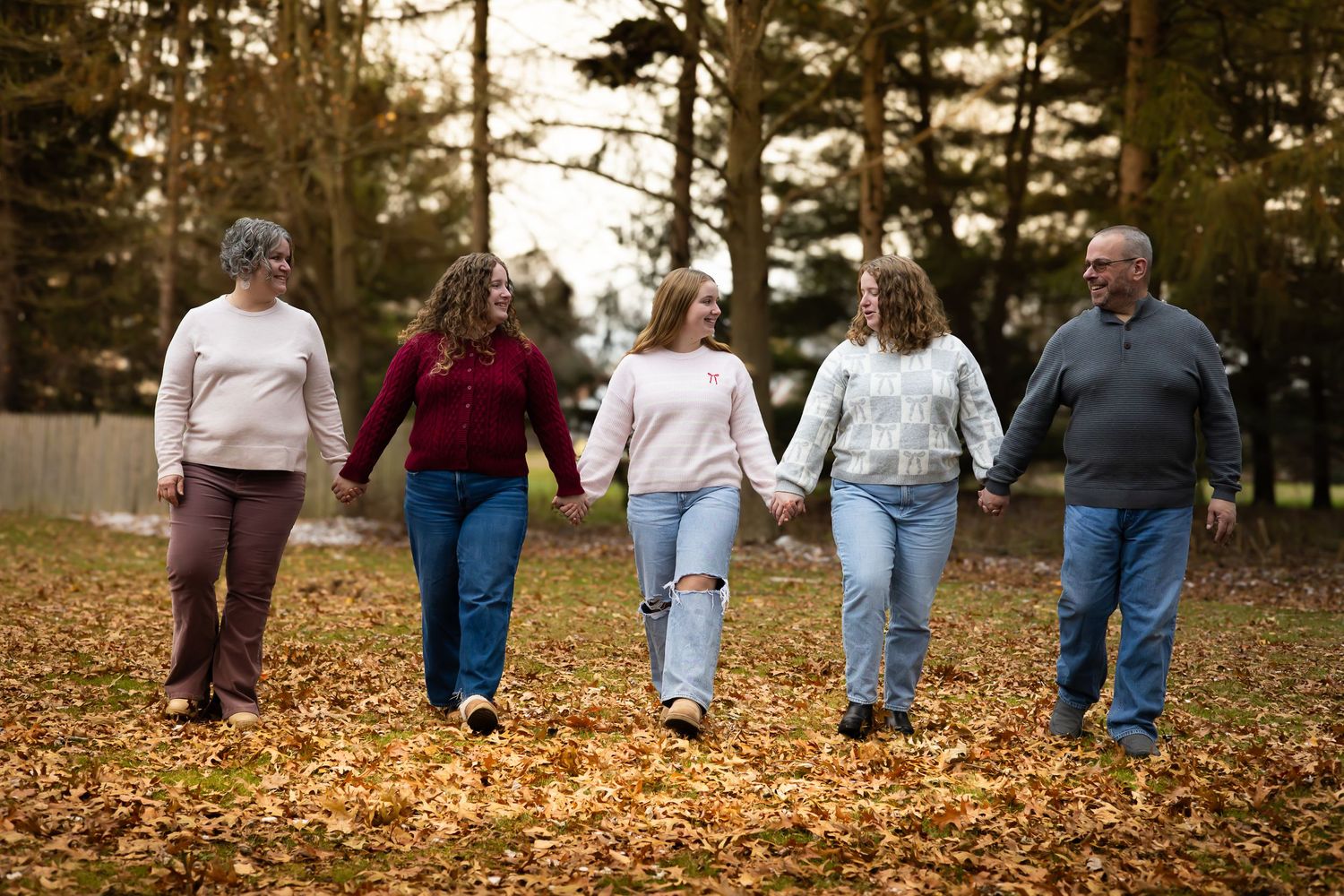 A family of 5 walking on maple leaves.