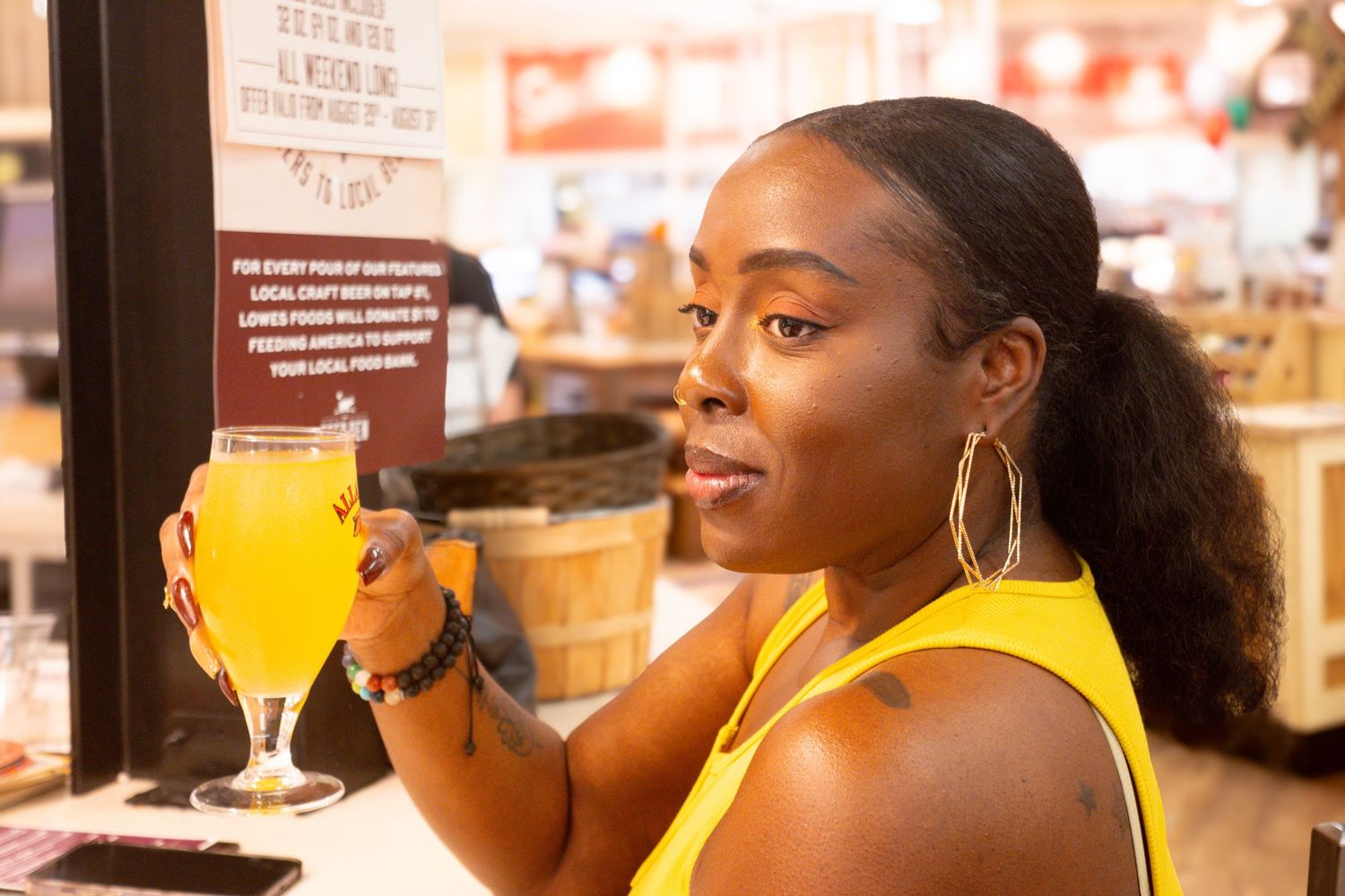 Group enjoying drinks at a bar with yellow cocktails in glasses.