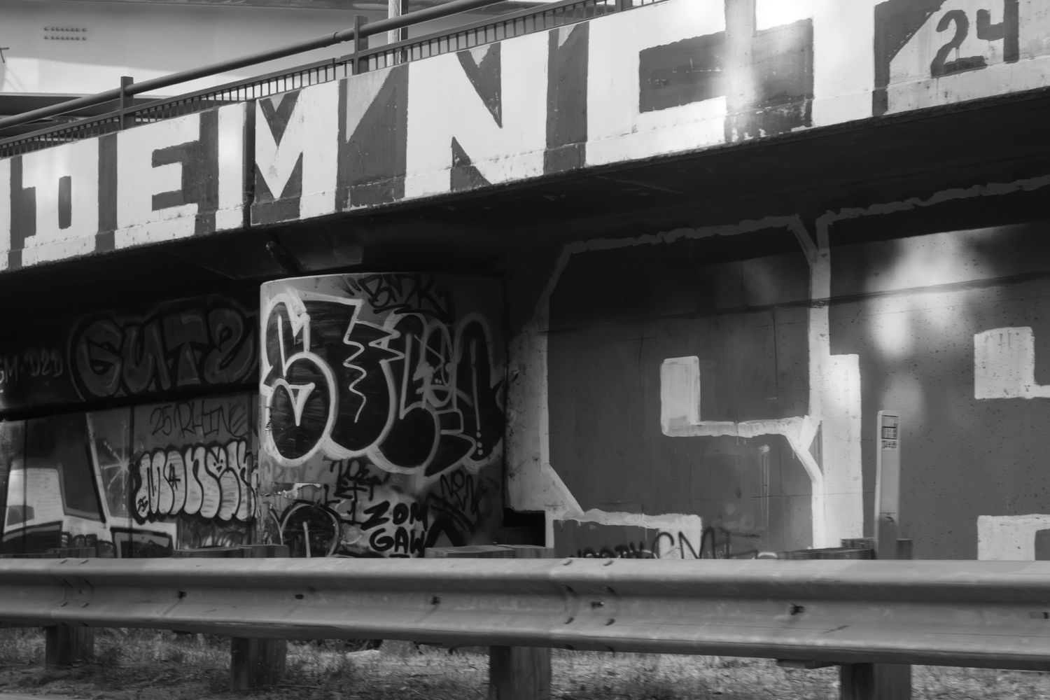 Black and white urban graffiti wall with text and street art designs.