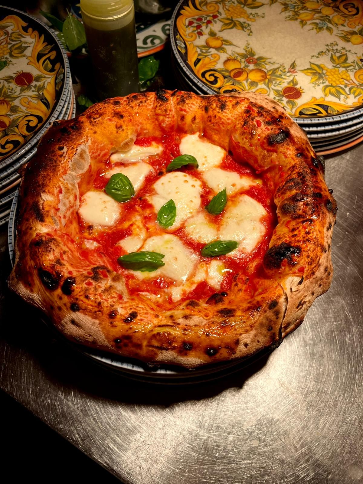 Classic Neapolitan Margherita pizza with fresh mozzarella, basil, and tomato sauce.