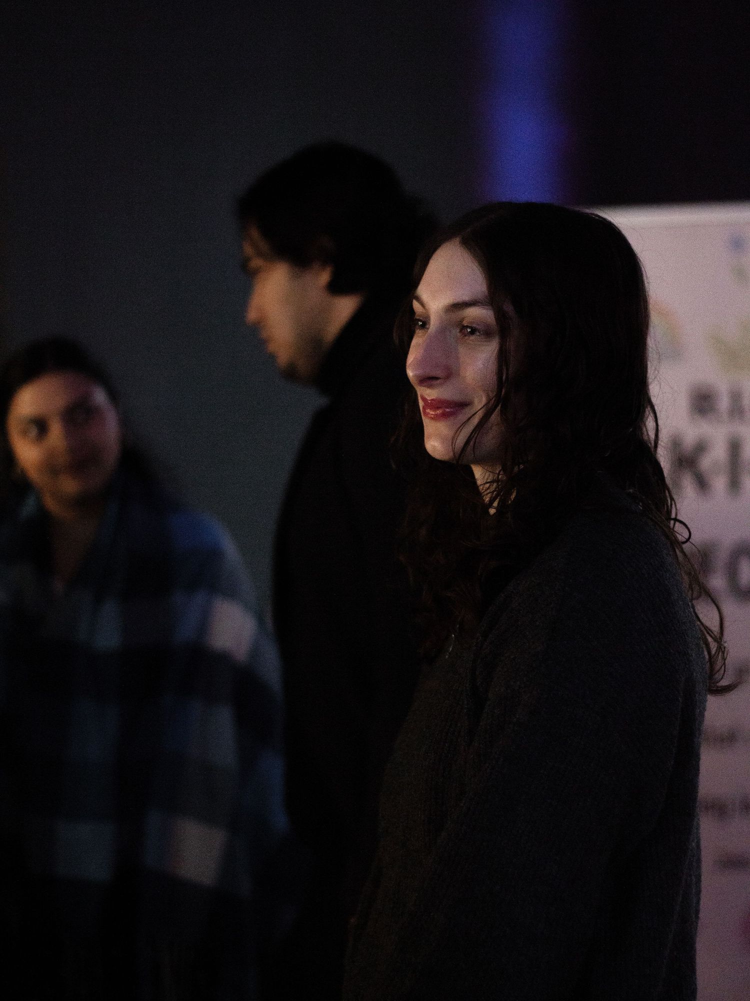 Portrait of a young lady smiling and general public blurred behind her.