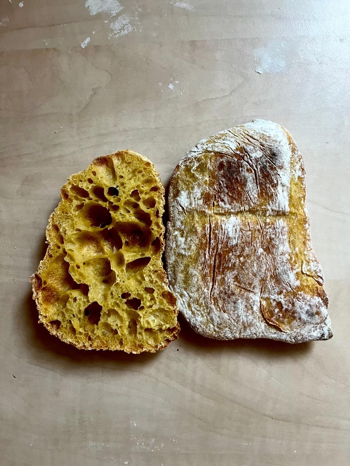 Two slices of artisan sourdough bread showing open crumb structure, one golden turmeric and one traditional white.