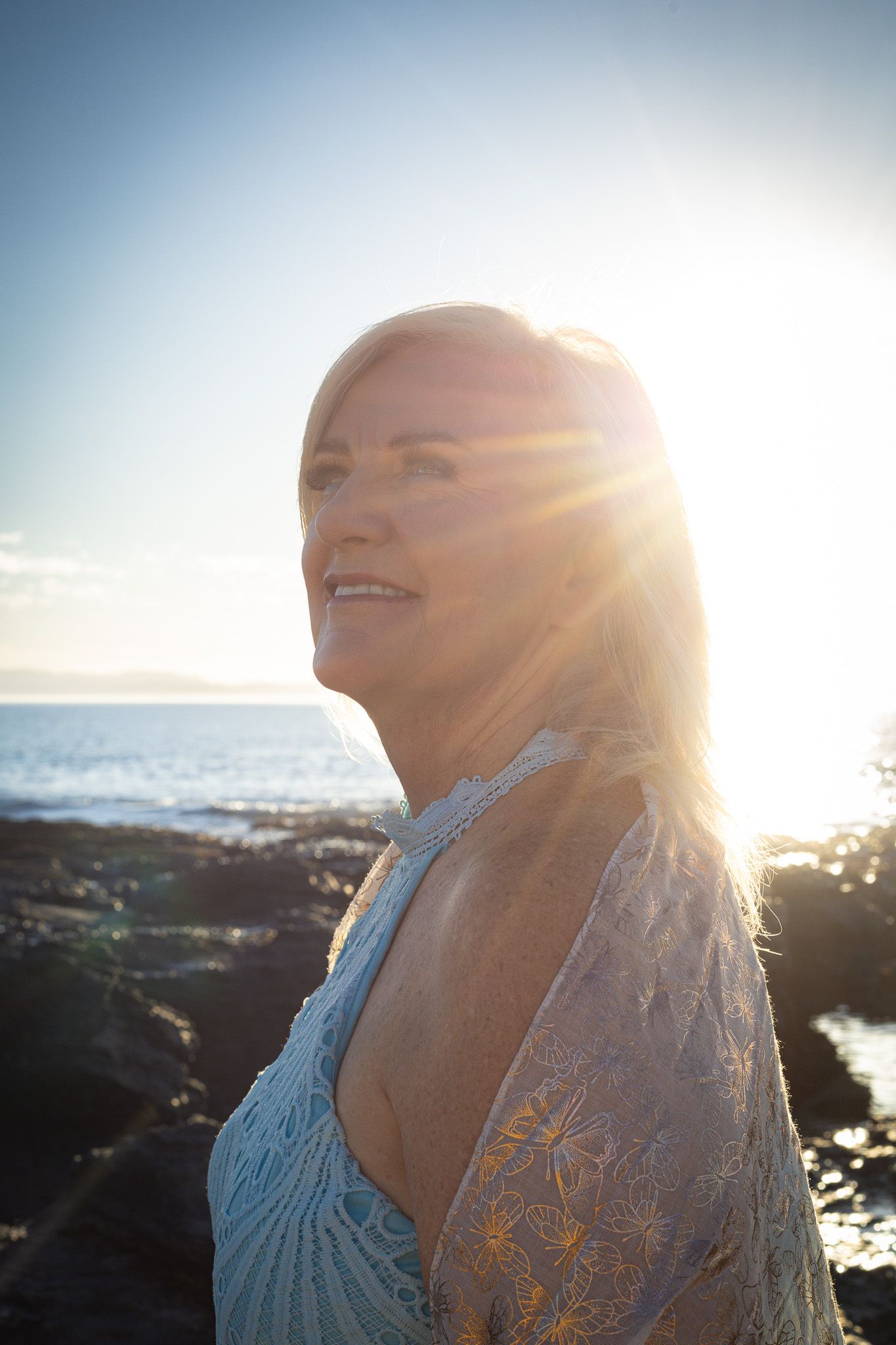 Portrait of a woman smiling while holding an umbrella. Portrait photography at the beach Eastern Cape Jeffreys Bay.