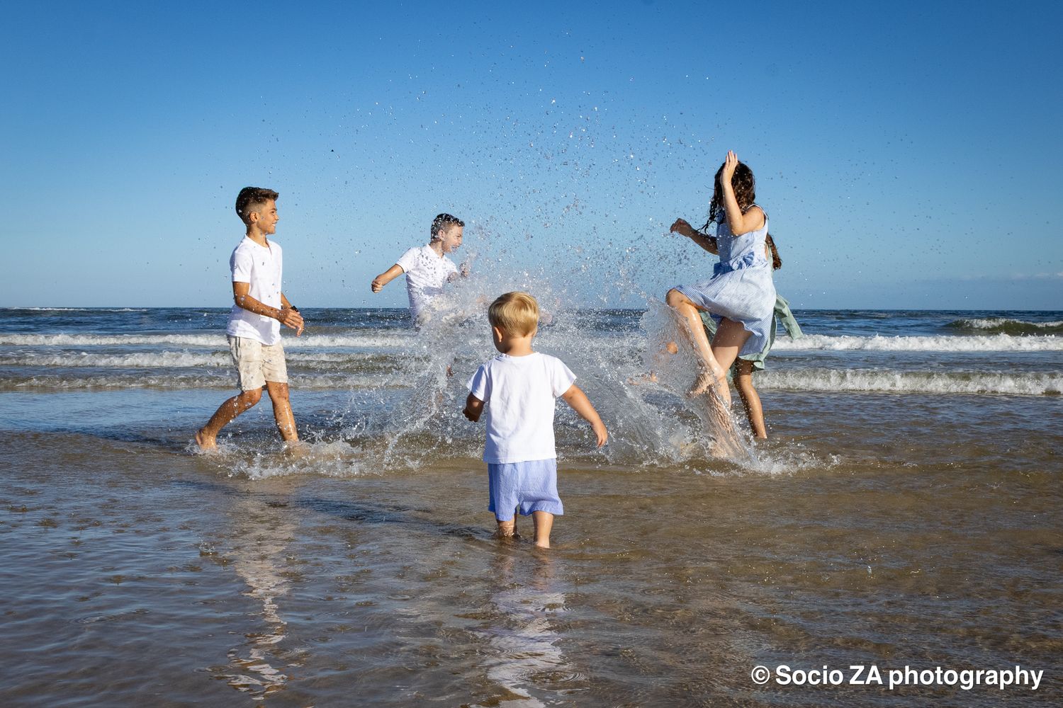 Children playing on the beach in the surf on a beautiful summer's day in the Eastern Cape in Jeffreys Bay.